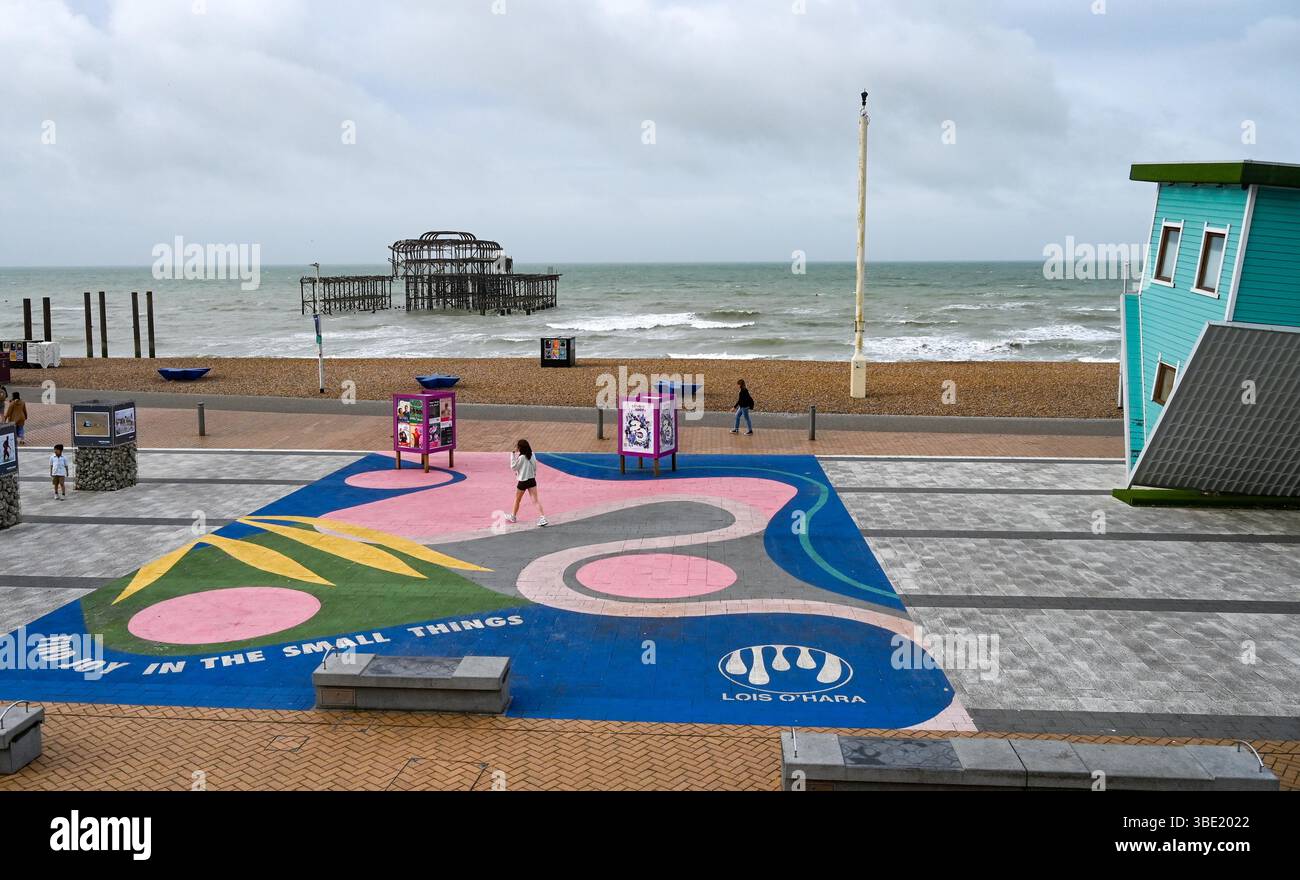 Brighton UK 27. Mai 2025 - Wanderer am frühen Morgen an einem windigen Morgen entlang der Brighton Küste, da unruhiges Wetter für Großbritannien prognostiziert wird: Credit Simon Dack / Alamy Live News Stockfoto