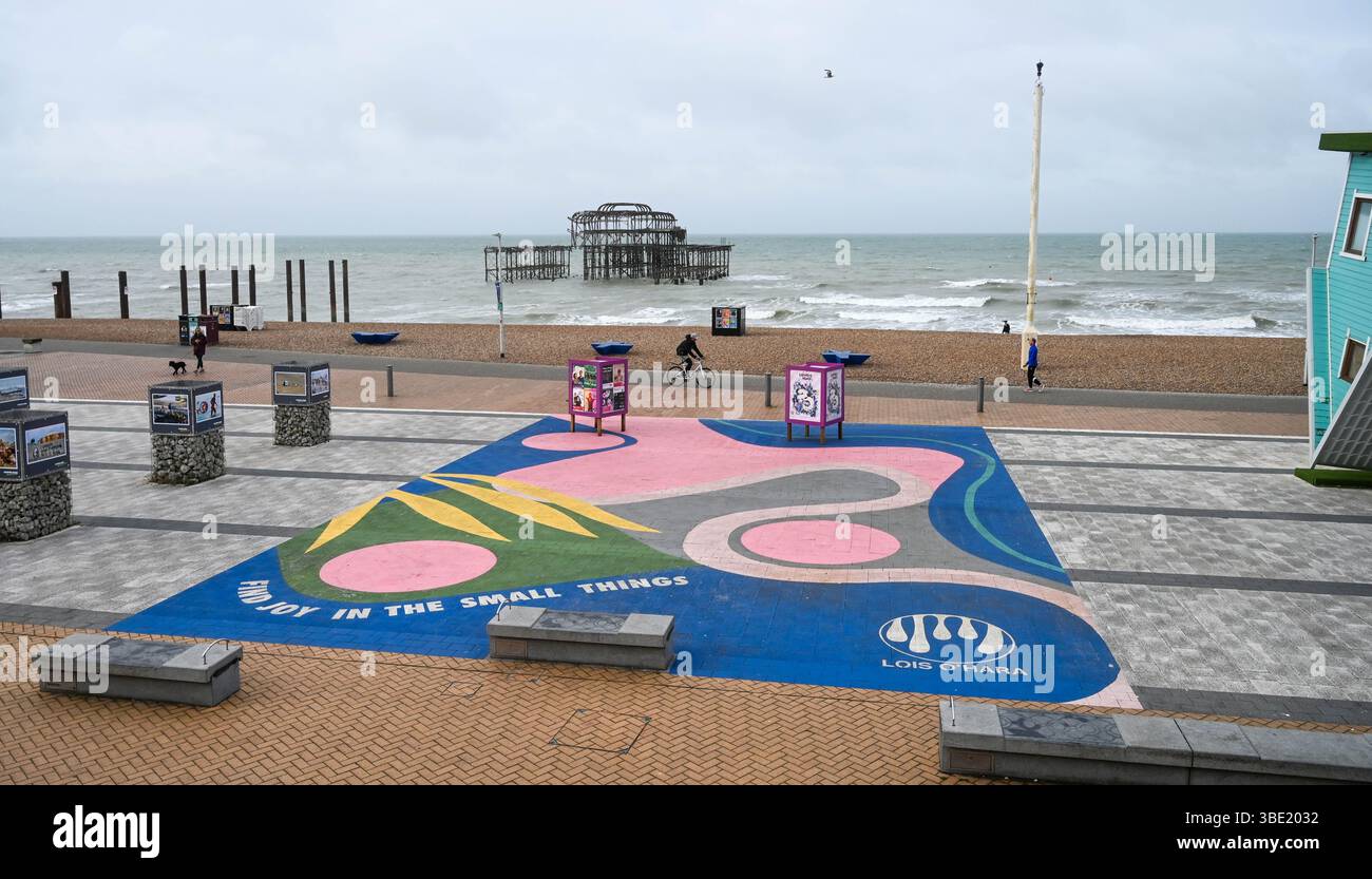 Brighton UK 27. Mai 2025 - Wanderer am frühen Morgen an einem windigen Morgen entlang der Brighton Küste, da unruhiges Wetter für Großbritannien prognostiziert wird: Credit Simon Dack / Alamy Live News Stockfoto