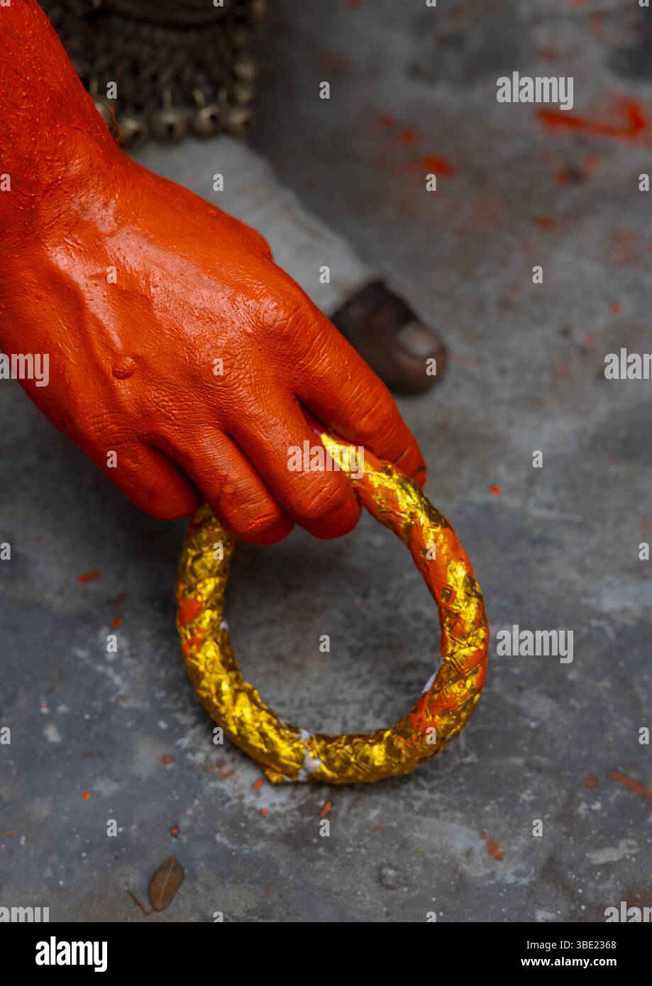 Hand und Armband eines hinduistischen Anhängers in Orange beim Lal Kach Festival, Dhaka Division, Munshiganj, Bangladesch Stockfoto