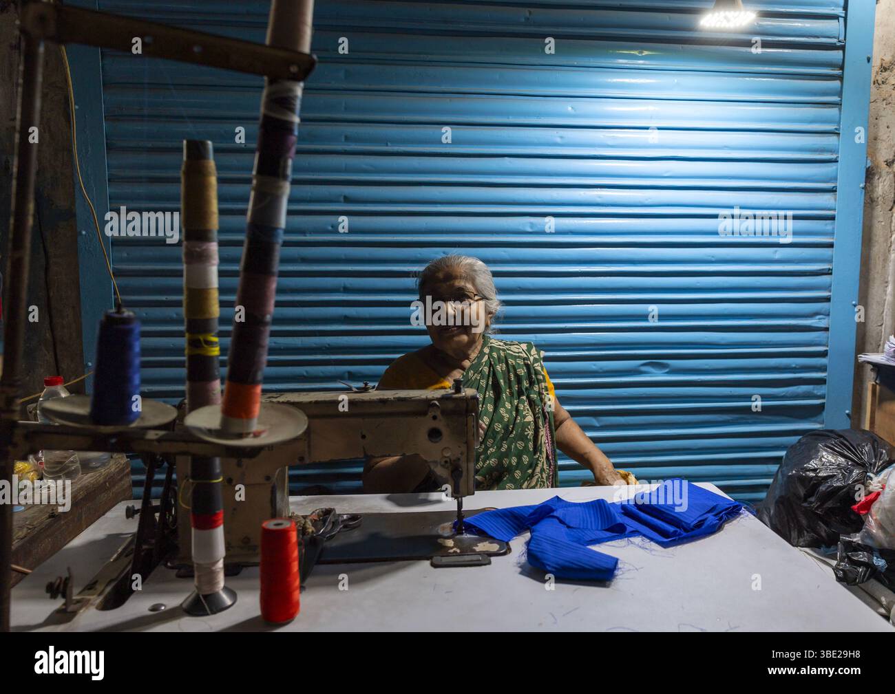 Bangladeshi alte Frau, die auf dem Markt nähen, Dhaka Division, Dhaka, Bangladesch Stockfoto