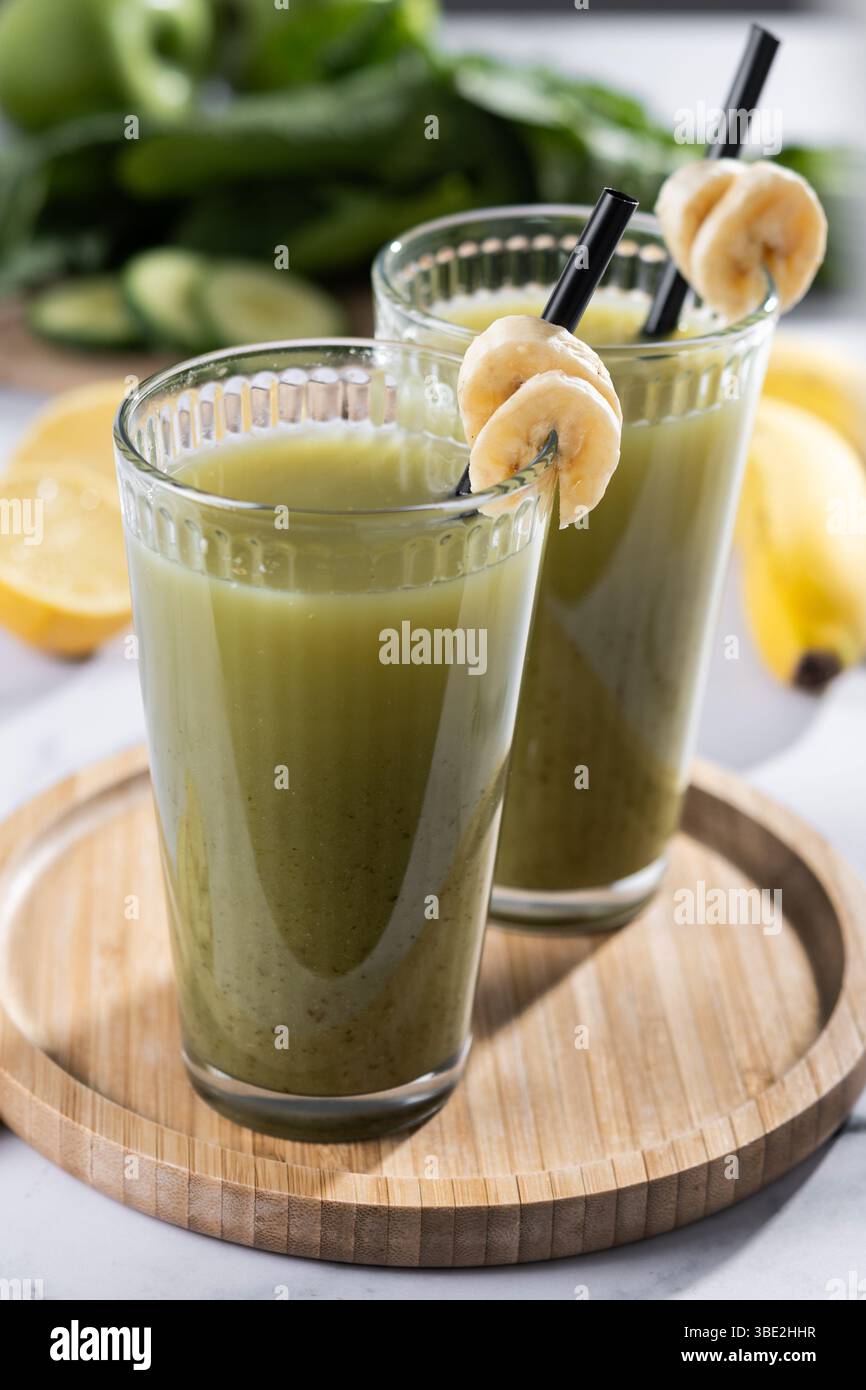 Grüner Smoothie mit Spinat, Banane, Apfel und Zitrone auf weißem Marmor Stockfoto