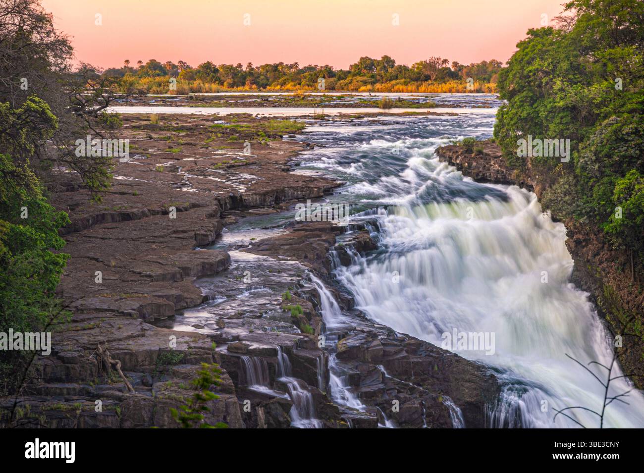 Simbabwe, die septentrionale Provinz Matabeleland, der Bezirk Hwange, der Victoria Falls National Park, der Zambezi River am UNESCO-Weltkulturerbe Victoria Falls, hier Devil's Falls am Ende der Trockenzeit bei Sonnenuntergang. Stockfoto