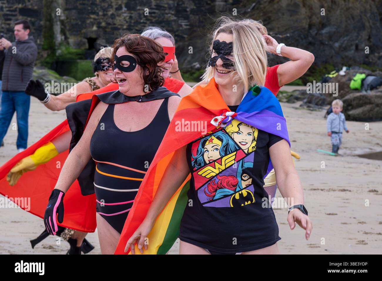 Die Teilnehmer treffen sich am Strand von Towan und bereiten sich auf die jährliche Veranstaltung „Superhero in the Cold“ vor, um Spenden für die britische Krebsforschung zu sammeln Stockfoto