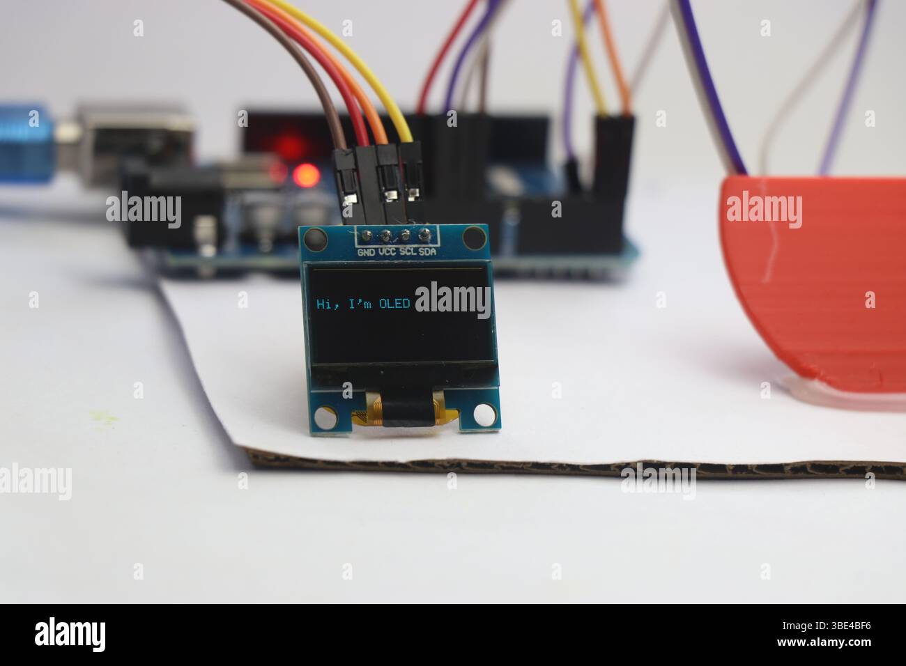 OLED-Modul, das über Jumperkabel mit einem programmierbaren Mikrocontroller verbunden ist und Text anzeigt. Kleine Komponenten für die Prototypenerstellung elektronischer Projekte Stockfoto
