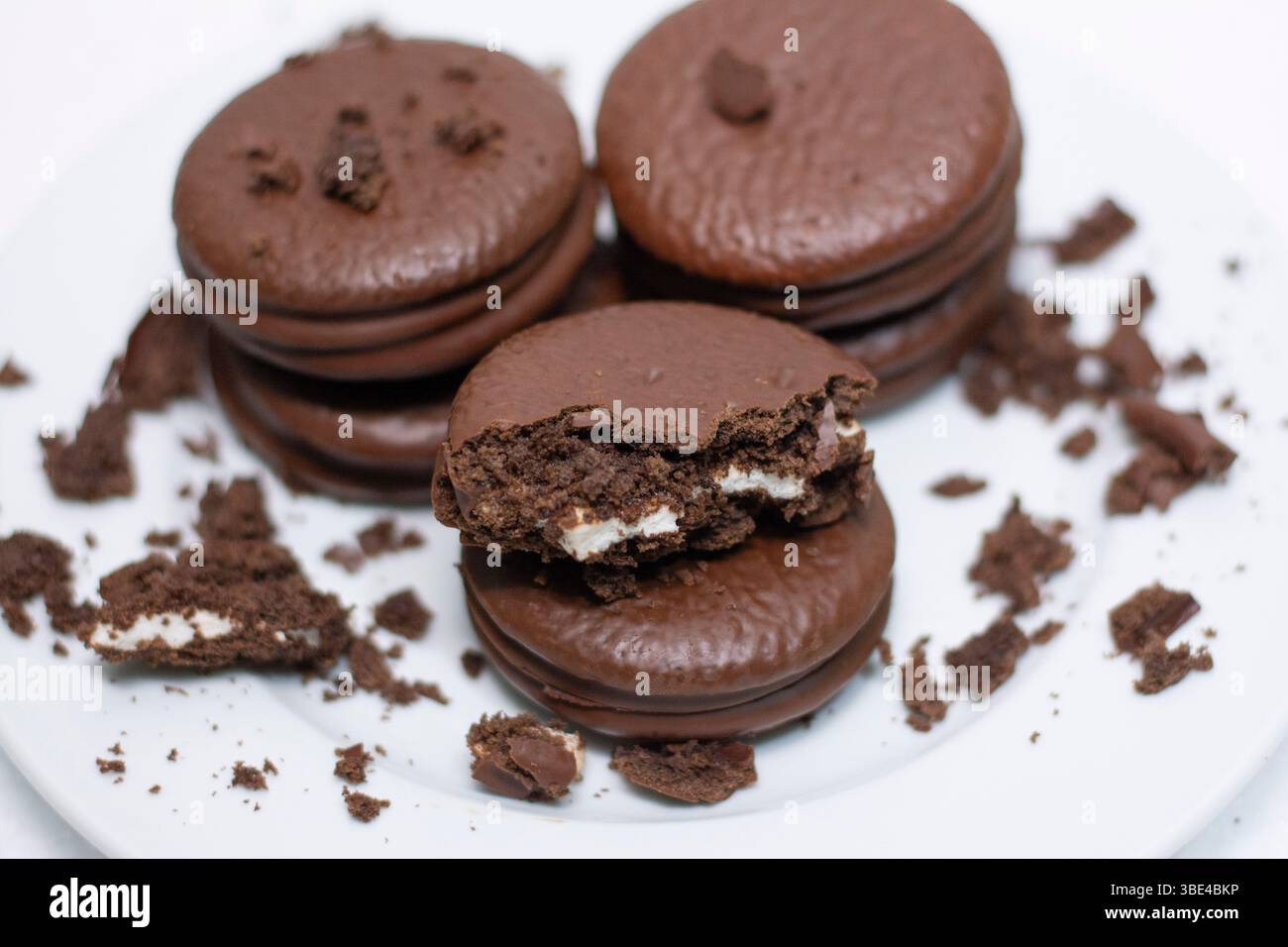 Leckere Schokolade mit süßlicher brauner Schokoladenhülle außen und weißer Kaucreme innen auf weißem Hintergrund Stockfoto