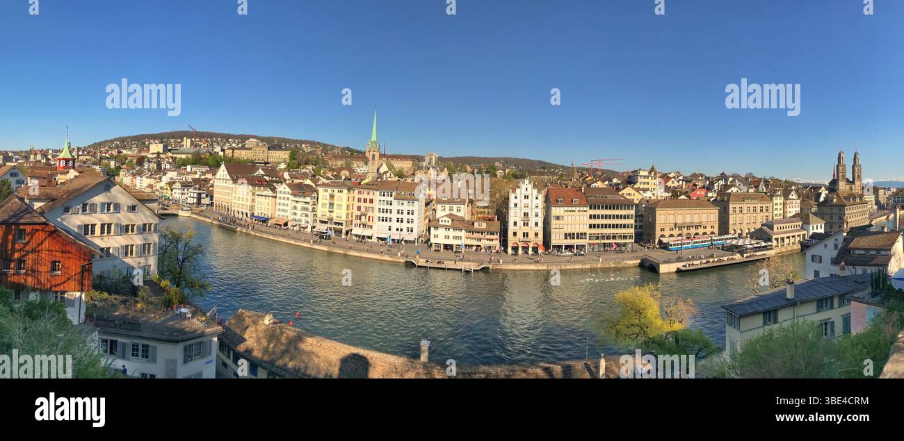 Weitwinkelpanorama mit Zürichs Stadtbild über die Limmat mit historischer Architektur und blauem Himmel. Stockfoto