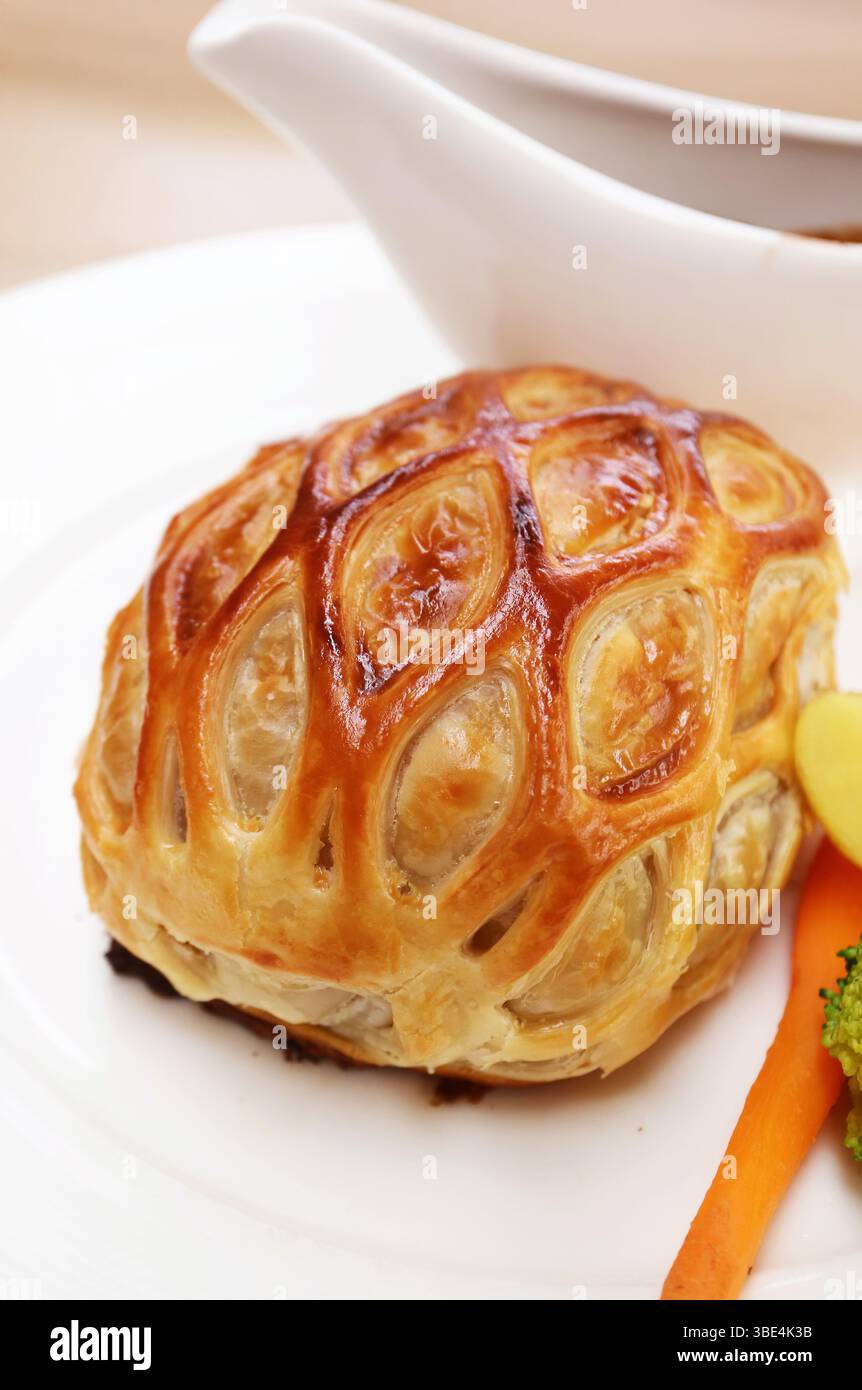 Nahaufnahme eines Tellers mit köstlichem Rindfleisch Wellington serviert mit Rotweinsauce Stockfoto