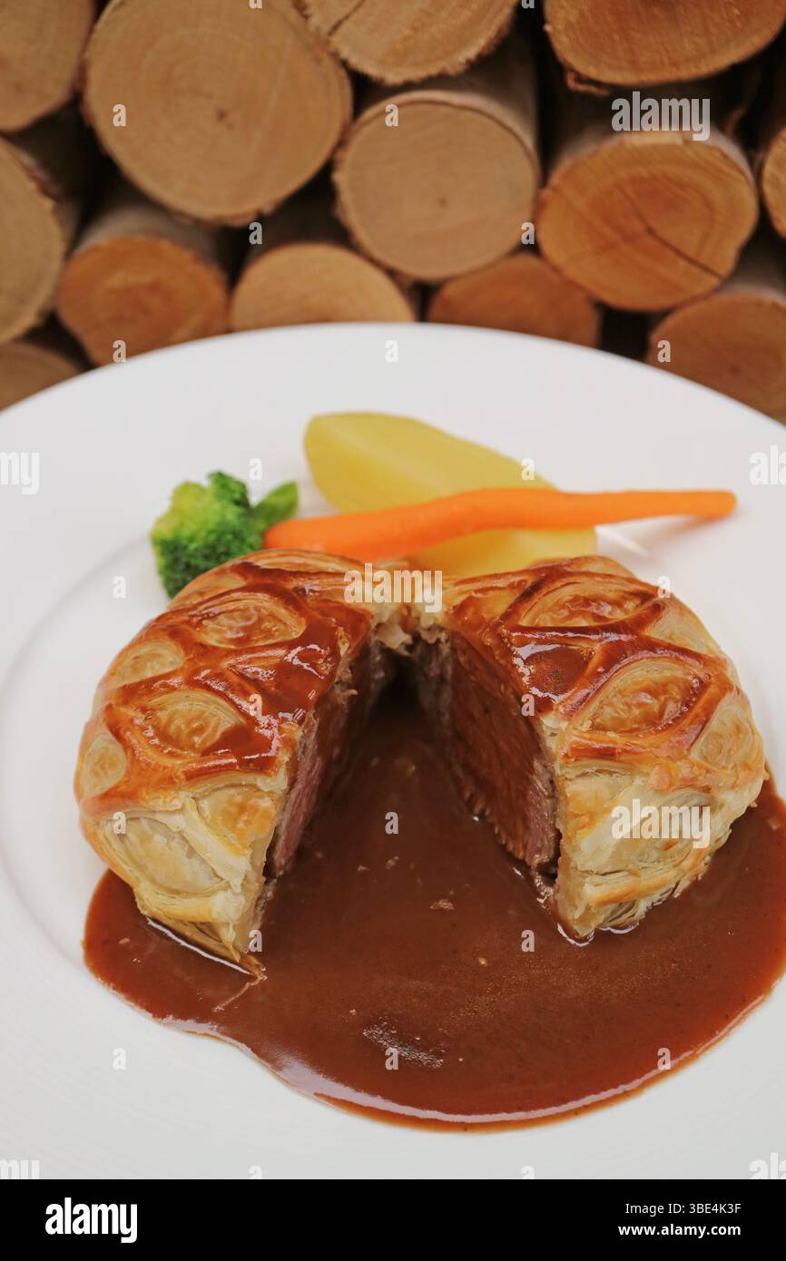 Ein Teller mit köstlichem Rindfleisch Wellington mit aromatischer Rotweinsauce Stockfoto