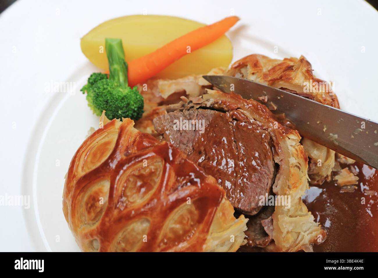 Nahaufnahme von aromatischem Rindfleisch Wellington mit Rotweinsauce Stockfoto