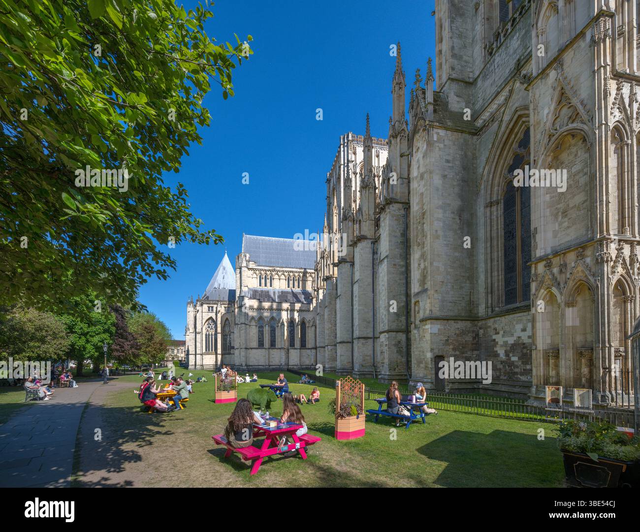 Leute picknicken im Dean's Park vor der Nordfassade des York Minster (York Cathedral), York, North Yorkshire, England, Vereinigtes Königreich Stockfoto