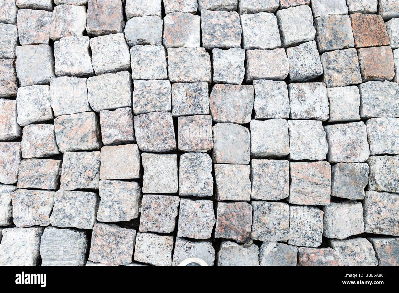 Blick von oben auf neue geteilte Steine auf Kopfsteinpflaster an der Stadtstraße Stockfoto