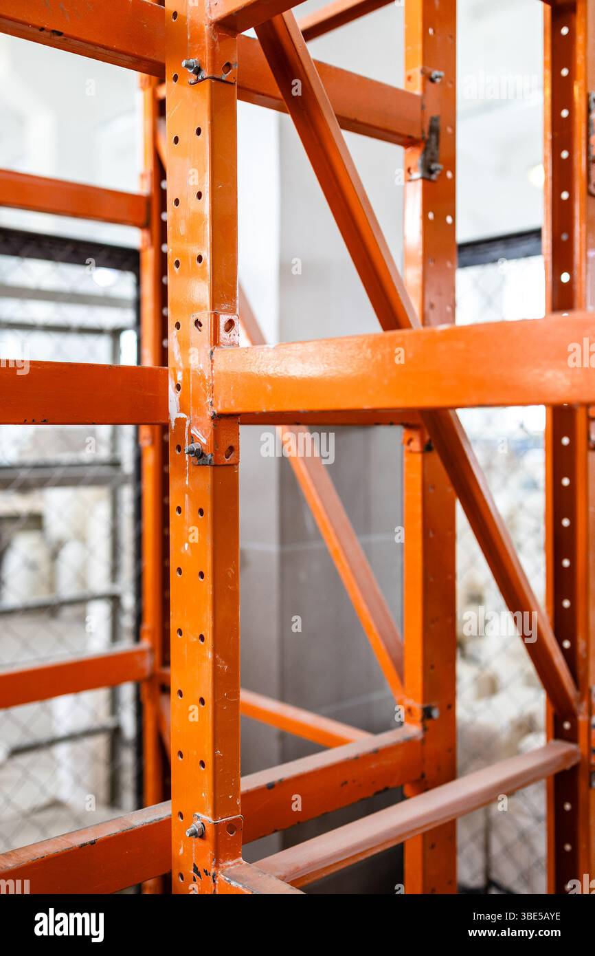 Orangefarbene Stahlregale in der Werkstattwerkstatt in der Nähe Stockfoto