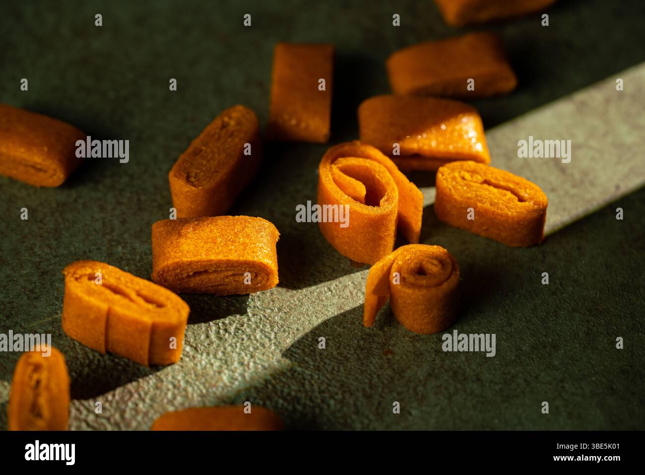 Nahaufnahme von Sanddorn- und Apfelfruchtelederrollen mit kräftiger Farbe und glatter Textur. Diese natürlichen Snacks sind lebendig Stockfoto