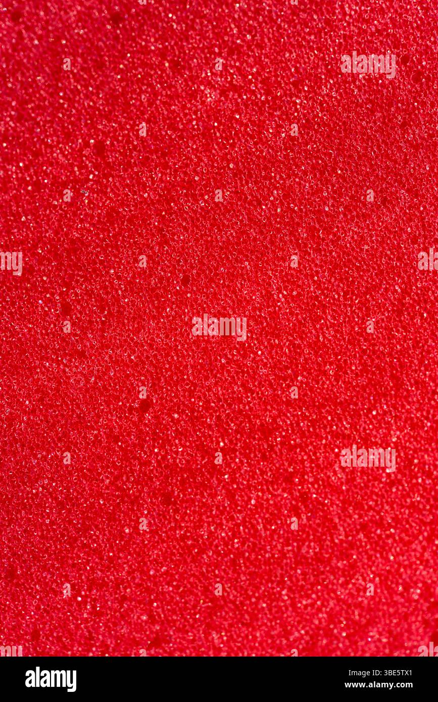 Hintergrund des porösen Schaumgummis. Roter Schaumgummi. Verpackungsmaterial. Stockfoto