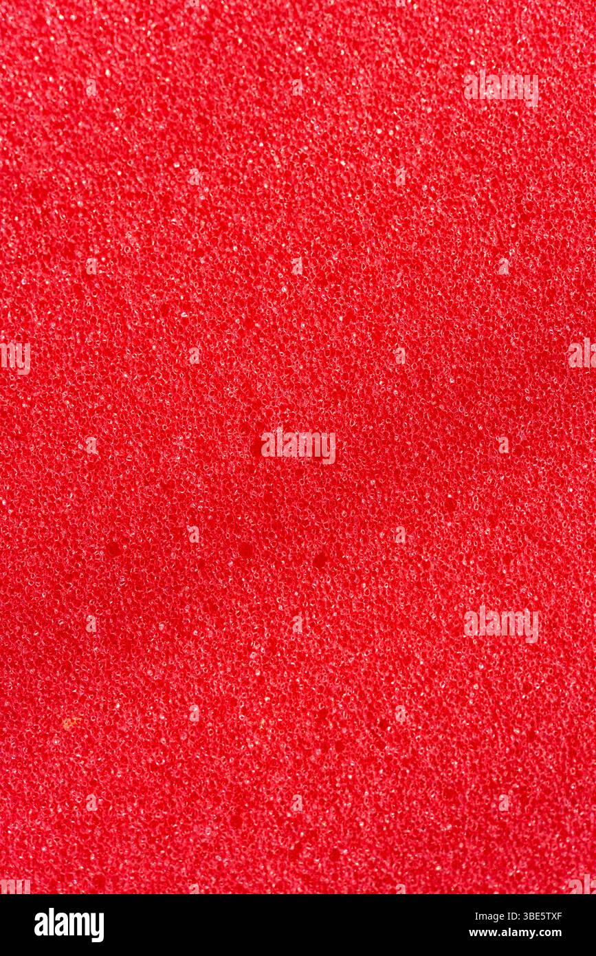 Hintergrund des porösen Schaumgummis. Roter Schaumgummi. Verpackungsmaterial. Stockfoto