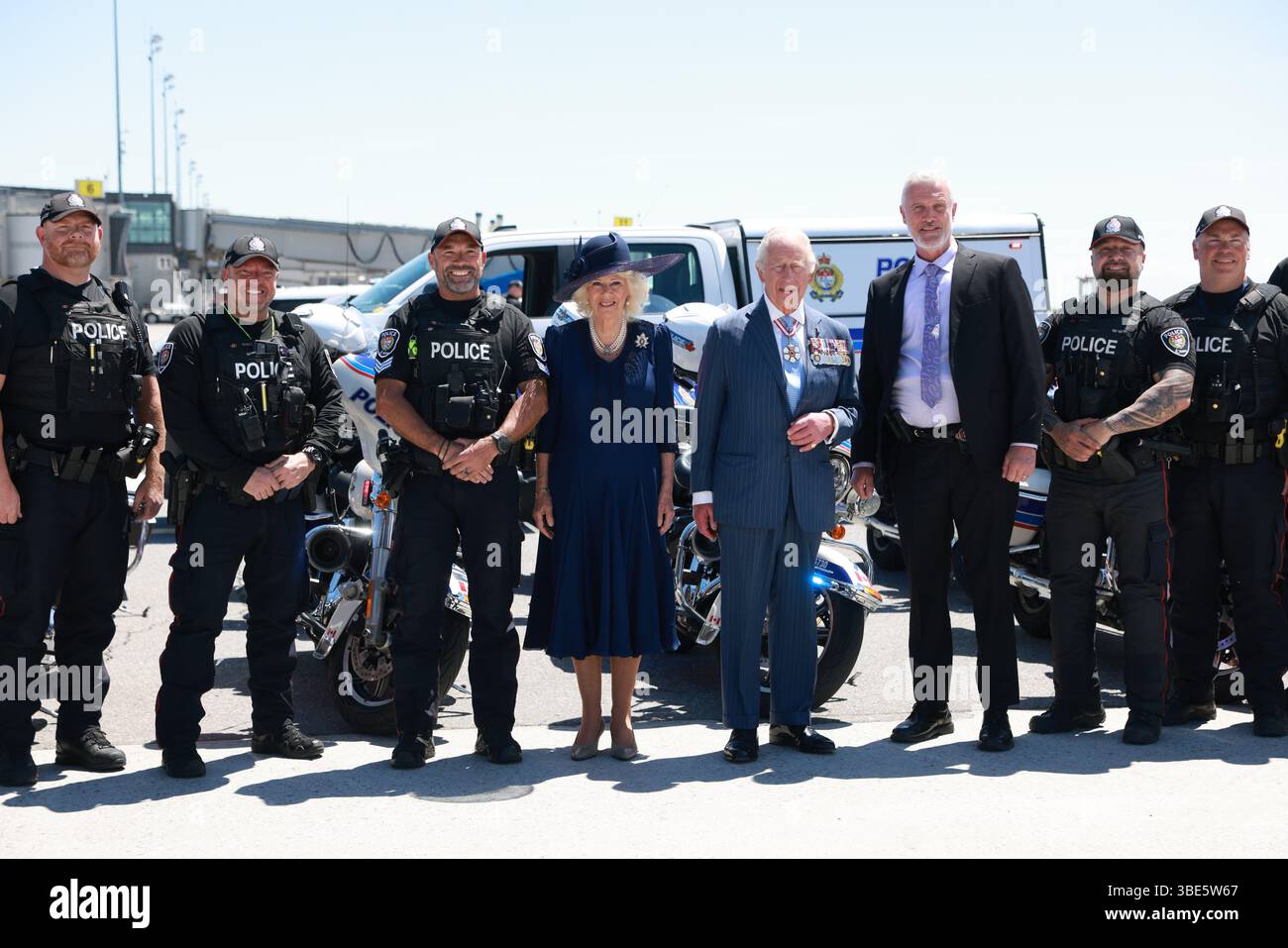 König Karl III. Und Königin Camilla posieren für ein Gruppenfoto mit Polizisten, bevor sie am Ende des königlichen zweitägigen Besuchs in Kanada in ihr Flugzeug steigen. Bilddatum: Dienstag, 27. Mai 2025. Stockfoto