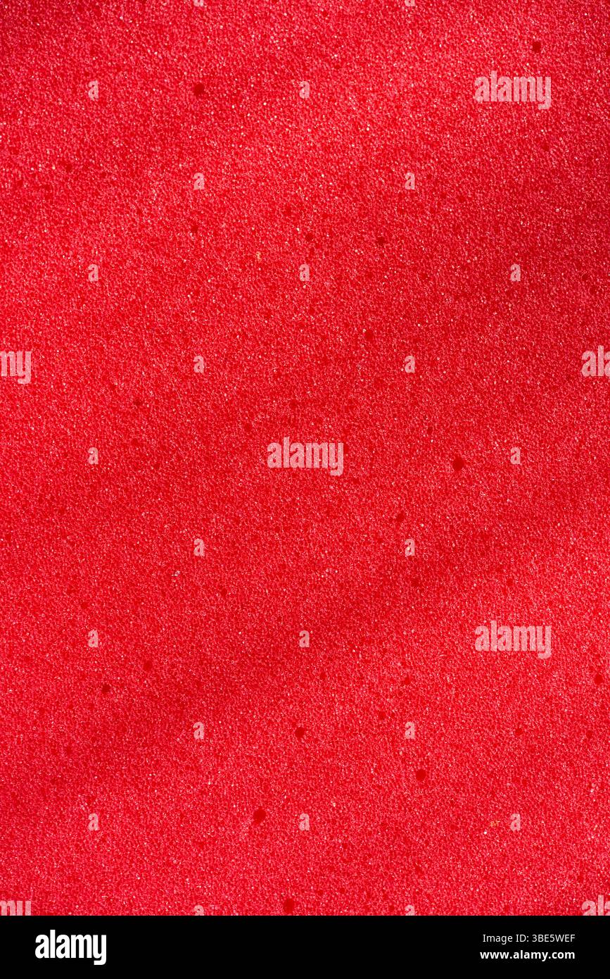 Hintergrund des porösen Schaumgummis. Roter Schaumgummi. Verpackungsmaterial. Stockfoto