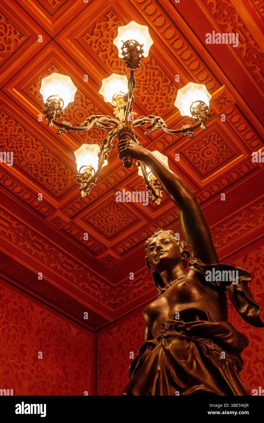 Bronzestatue am Eingang des Theatro da Paz mit komplizierten Kassettendecken und Beleuchtungselementen im Foyer der Belle Epoque. Stockfoto