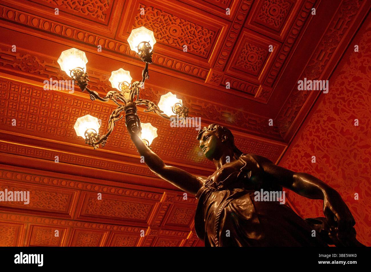 Bronzestatue am Eingang des Theatro da Paz mit komplizierten Kassettendecken und Beleuchtungselementen im Foyer der Belle Epoque. Stockfoto