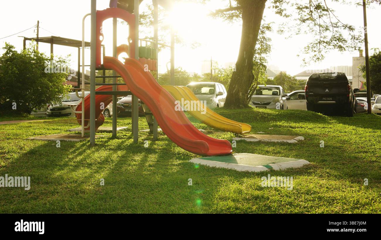 Die malerische Aussicht auf einen Kinderspielplatz am Morgen mit der Sonne im Hintergrund. Stockfoto