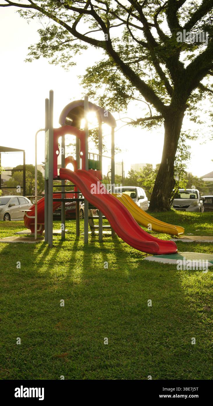 Die malerische Aussicht auf einen Kinderspielplatz am Morgen mit der Sonne im Hintergrund. Stockfoto