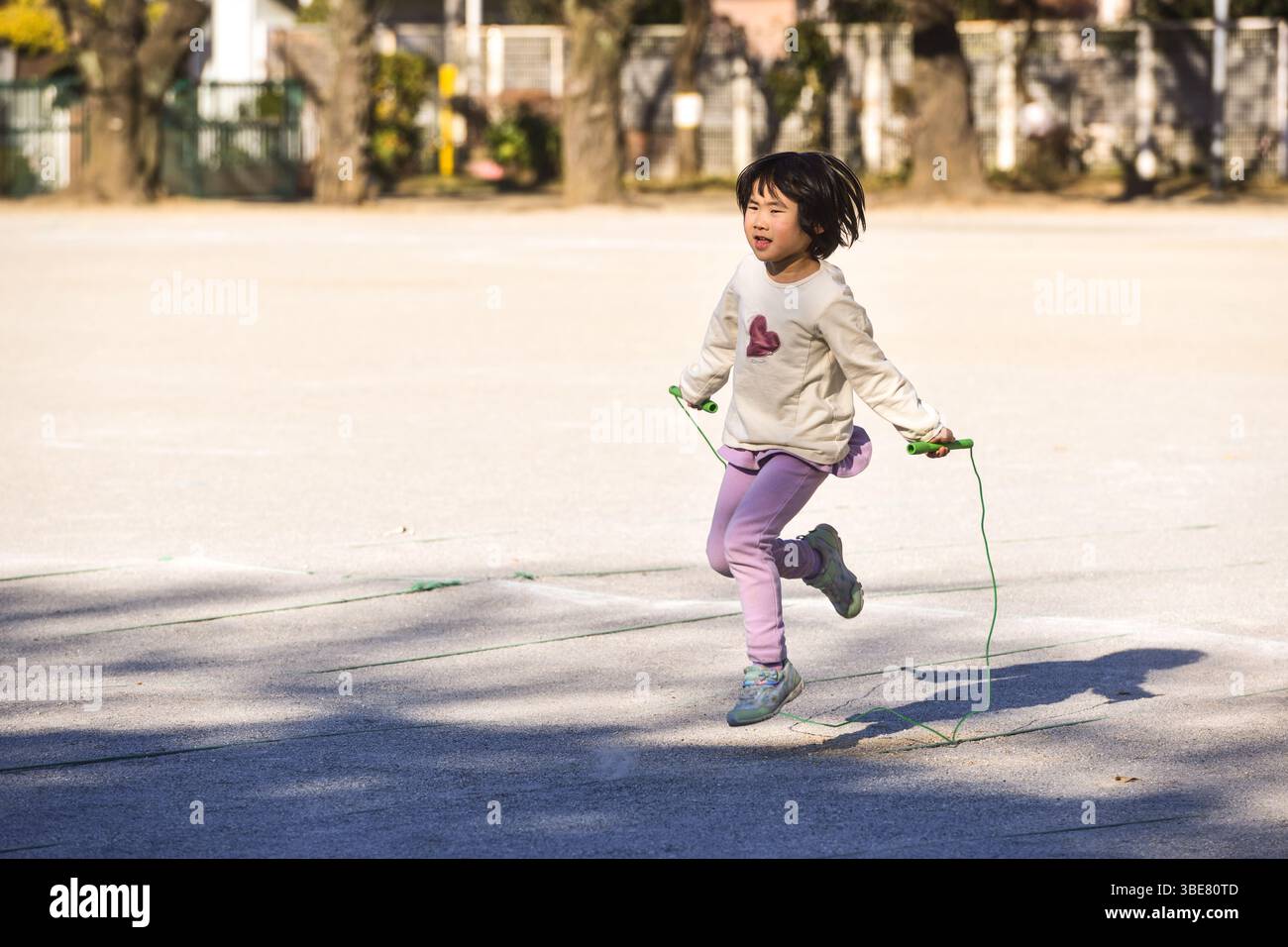 Kleinkind spielt Sprungseil Stockfoto