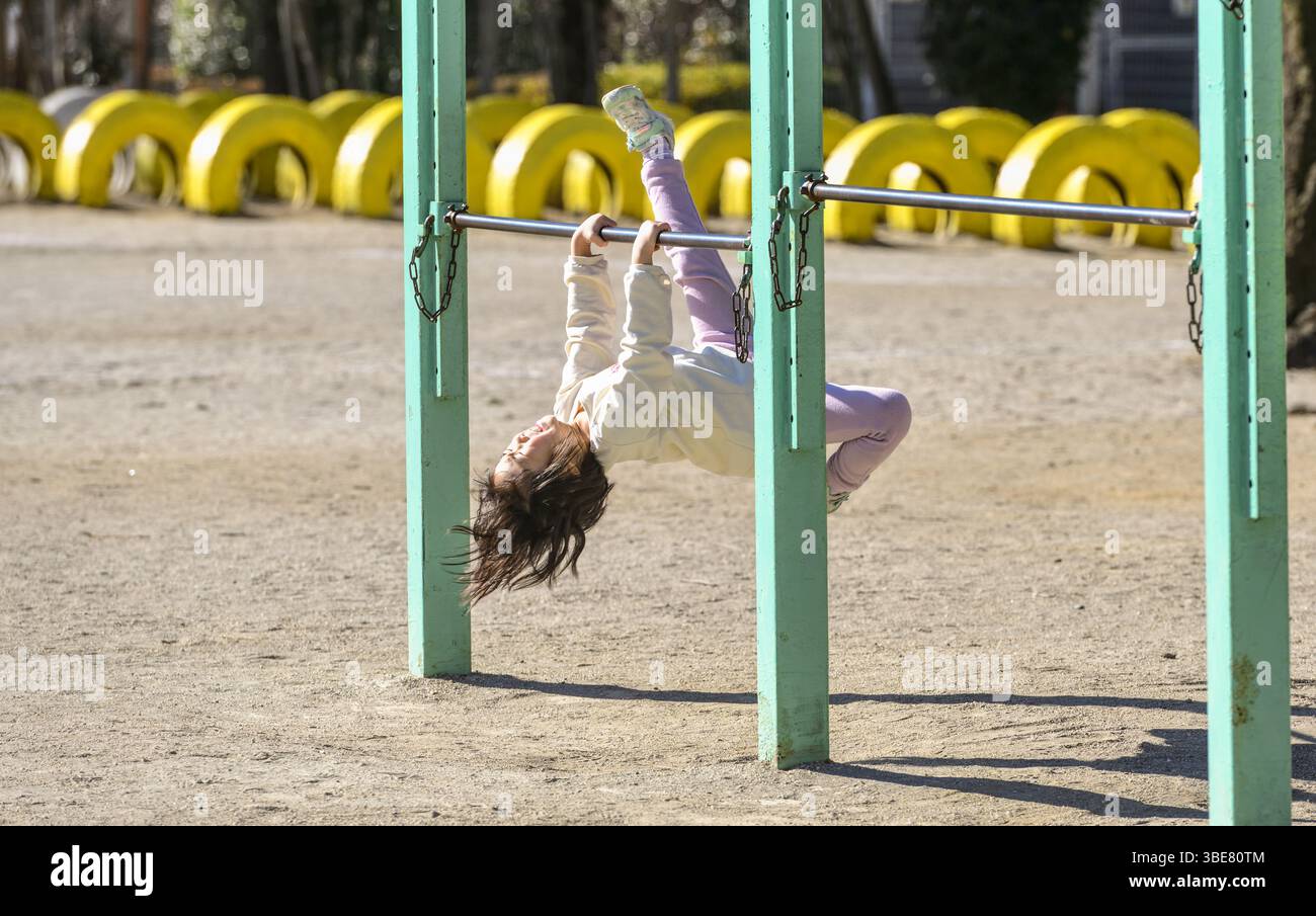 Mädchen, das versucht, die Bars hochzuklettern Stockfoto