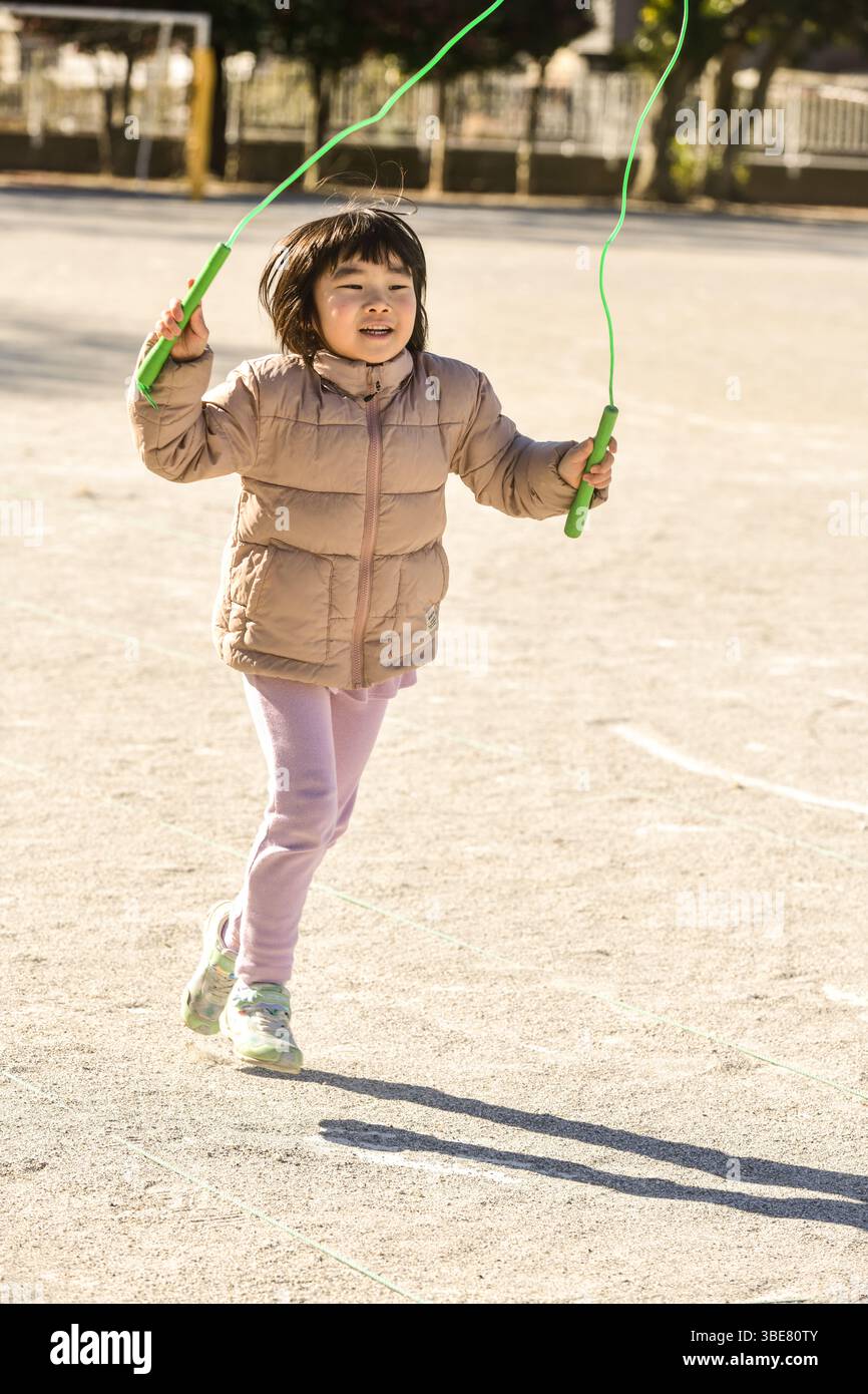 Kleinkind spielt Sprungseil Stockfoto
