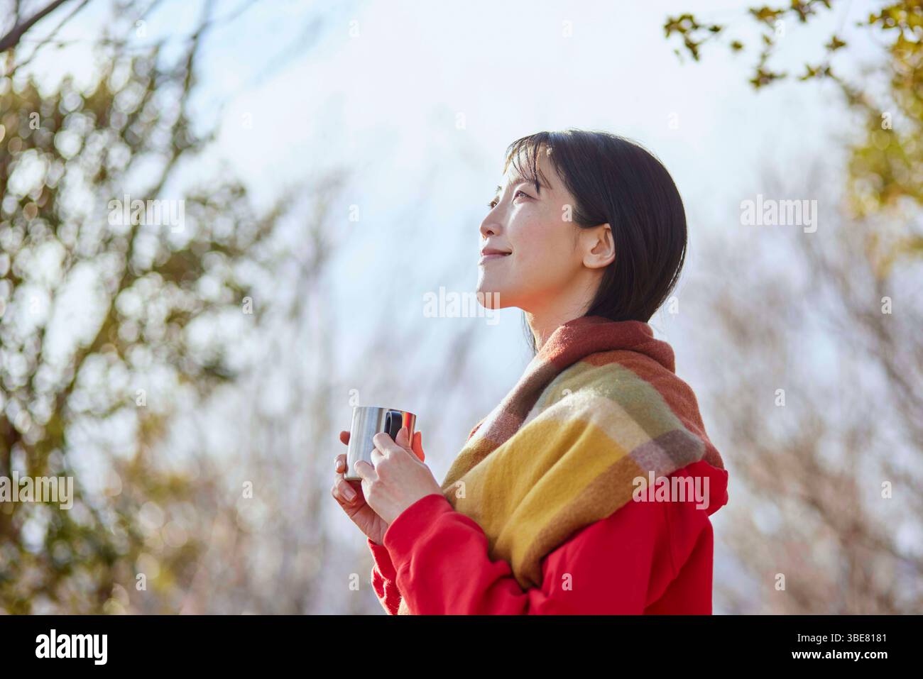 Japanerin genießt die Natur mit einer Tasse Kaffee in den Winterbergen. Stockfoto