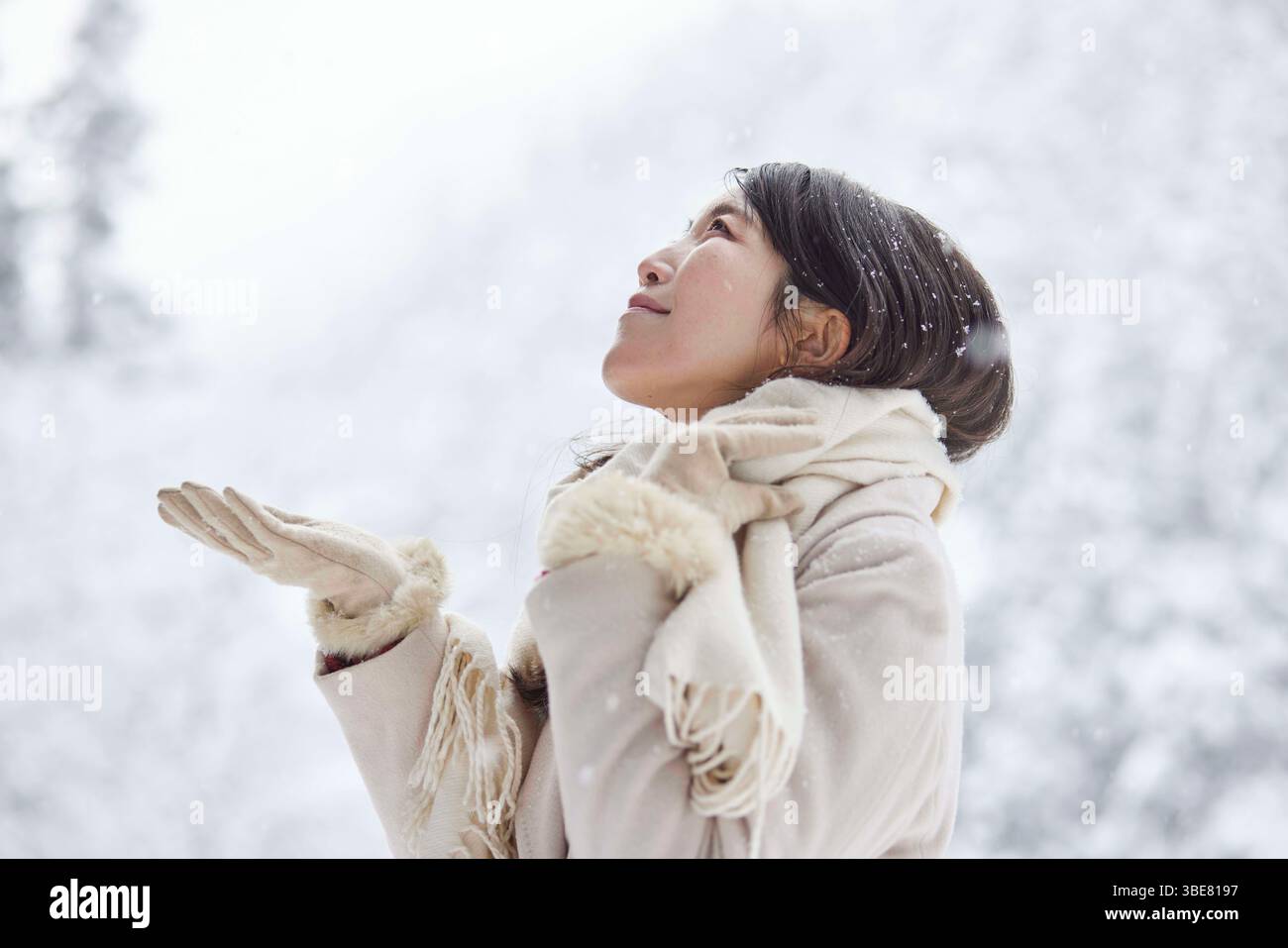 Japanerin, die einen Schal trägt, steht im Winter in einem verschneiten Land Stockfoto