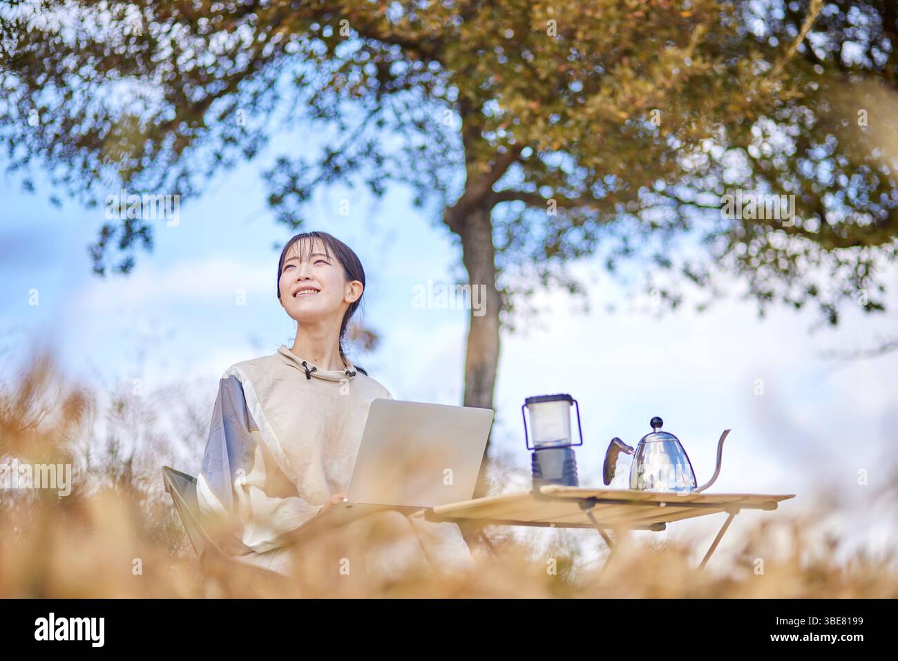 Japanische Frau, die im Winter mit ihrem Computer draußen in den Bergen genießt Stockfoto