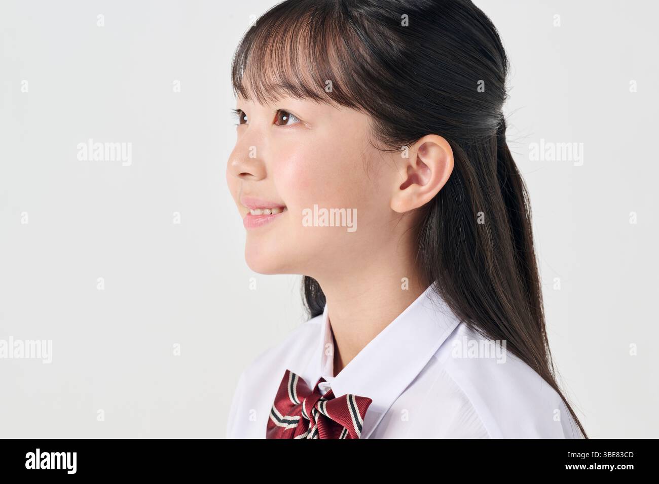 Weißer Hintergrund, japanisches Mädchen der Junior High School, lächelnd Stockfoto