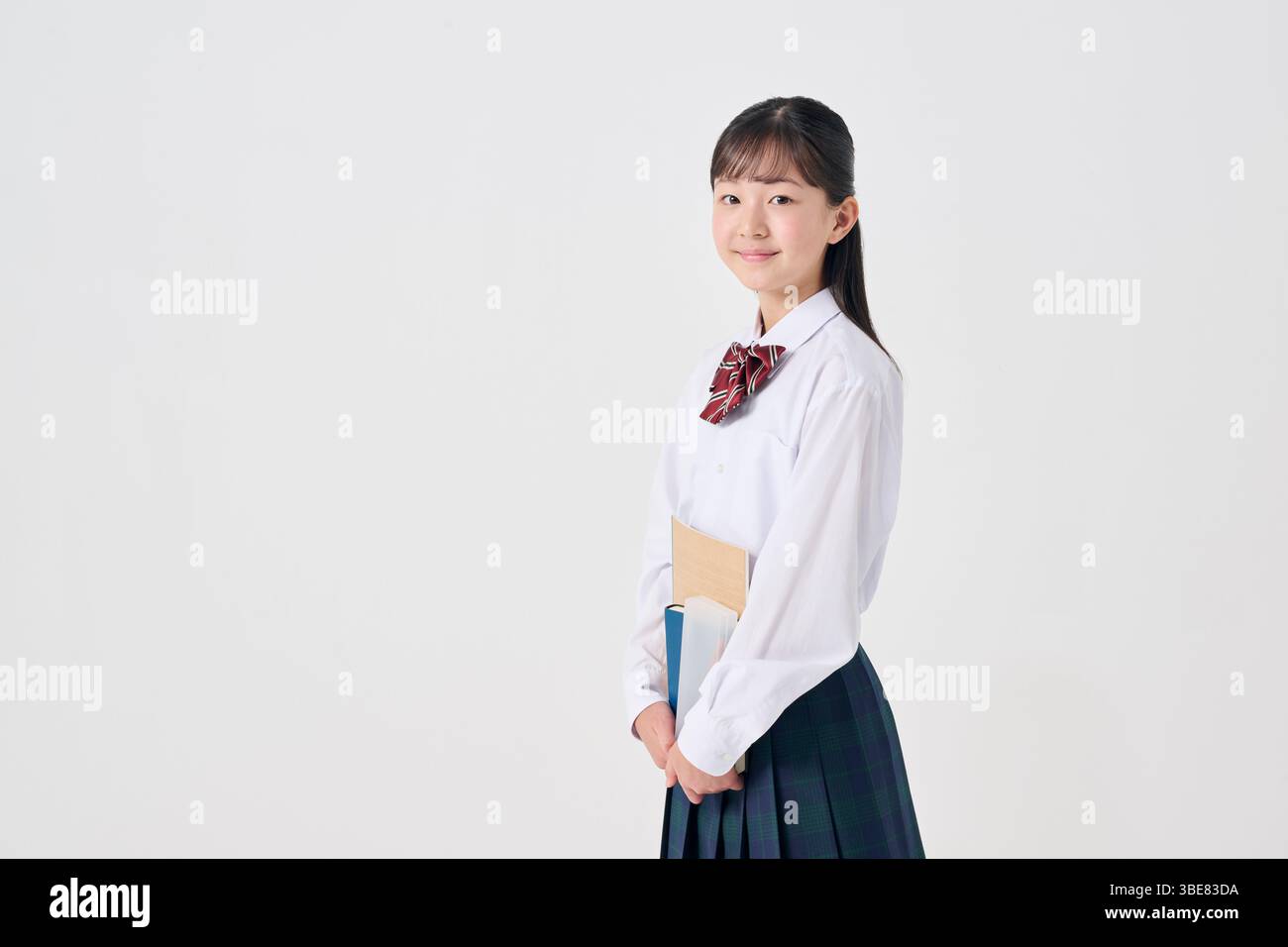 Japanische Schülerin mit Lernmaterial, weißer Hintergrund Stockfoto