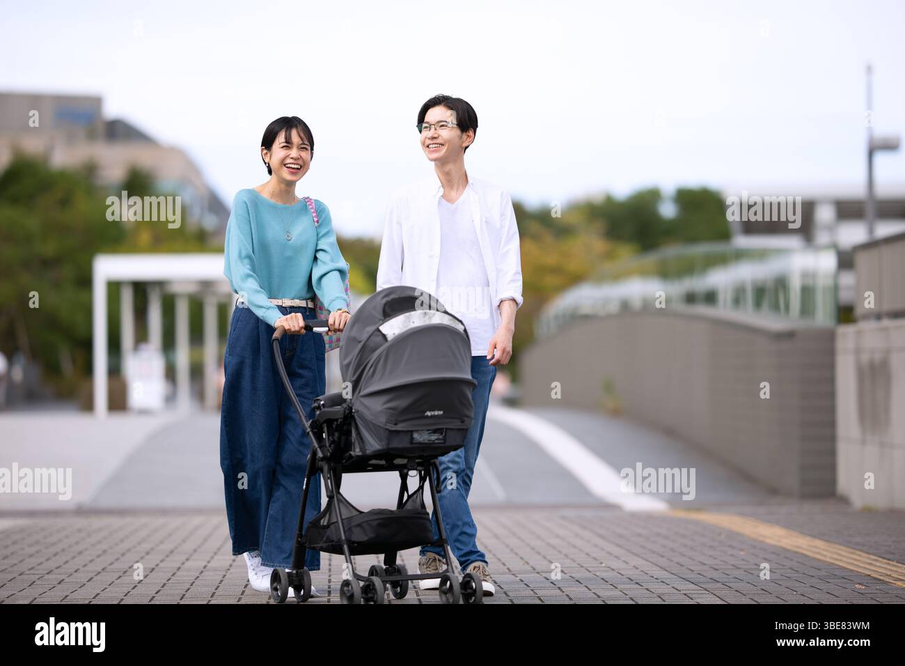 Paare gehen, während sie den Kinderwagen schieben Stockfoto