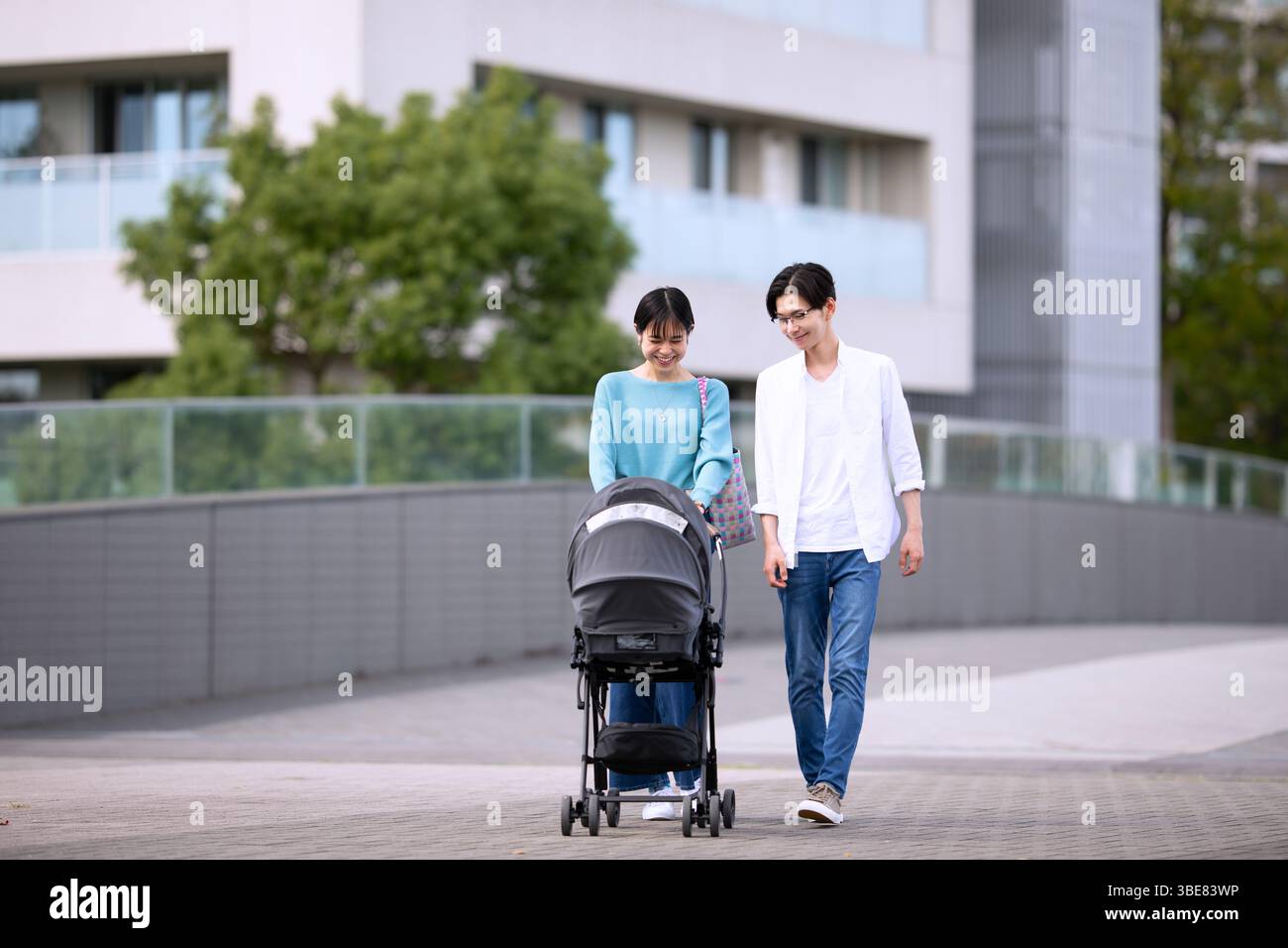 Paare gehen, während sie den Kinderwagen schieben Stockfoto
