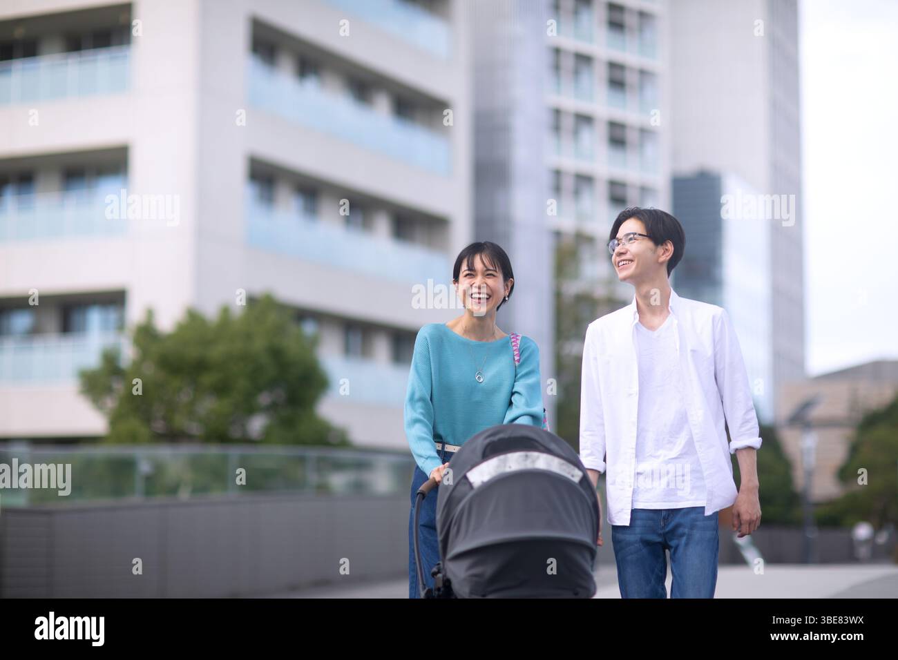 Paare gehen, während sie den Kinderwagen schieben Stockfoto