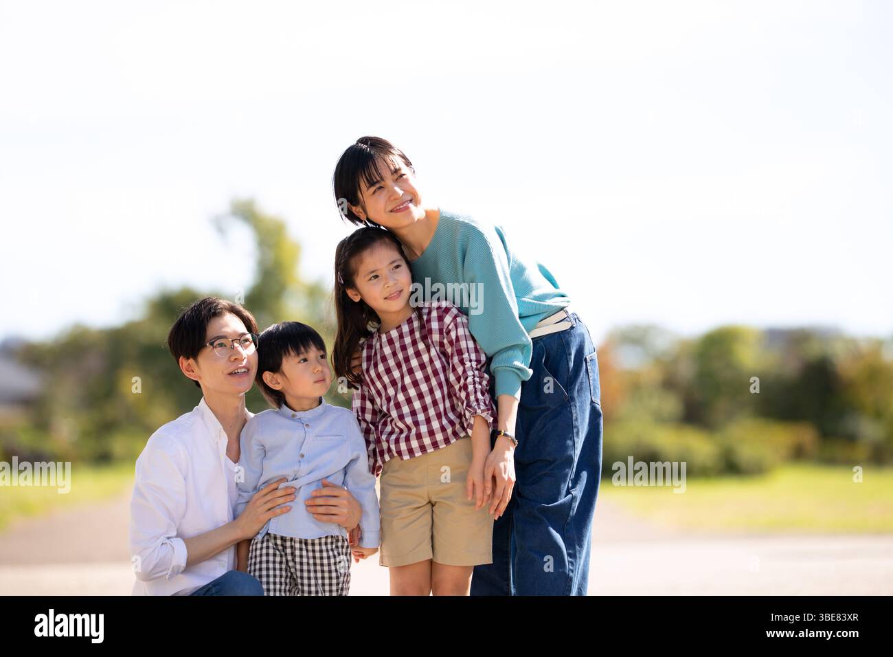 Vierköpfige Familie mit Blick in die Ferne im Park Stockfoto