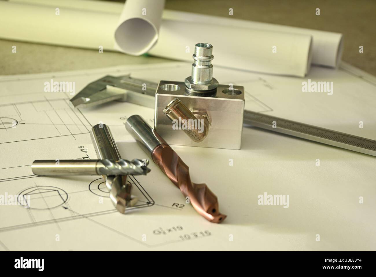 Metallbohrer, Fräser und ein Messschieber werden auf einer technischen Zeichnung verlegt. Stockfoto