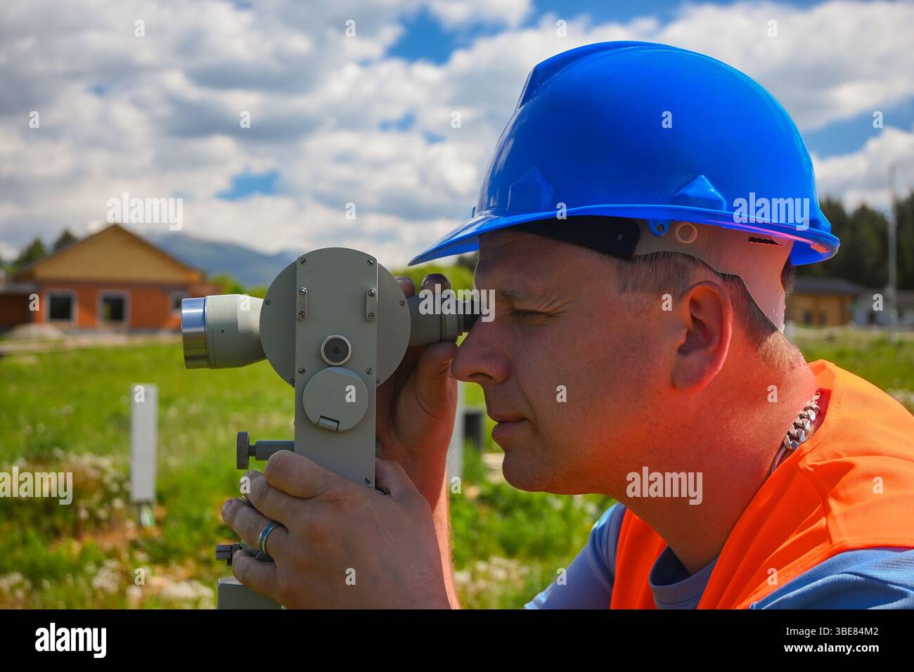 Vermesser bei Messungen mit Theodolit auf einer Baustelle. Stockfoto