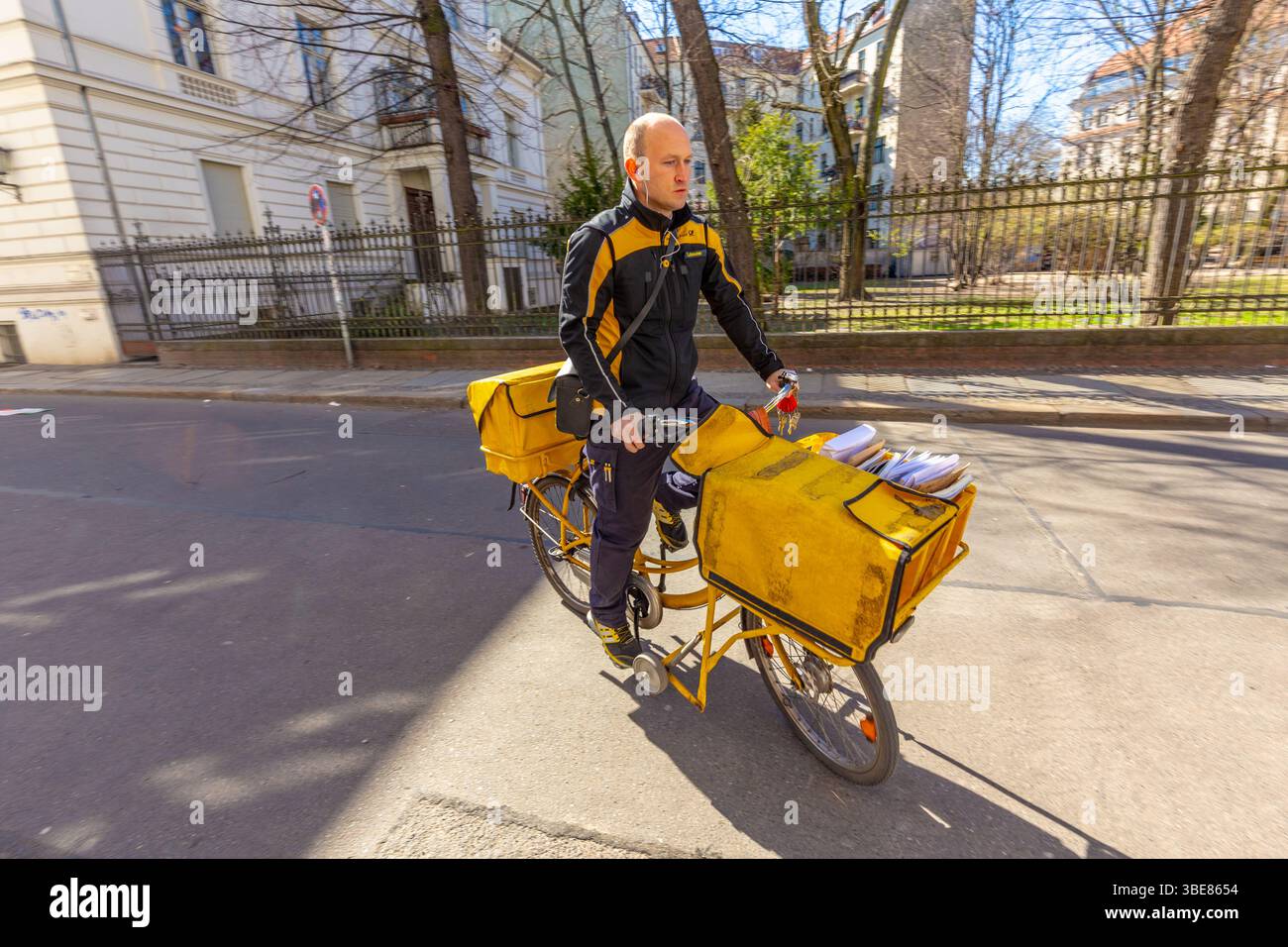 Berlin, Deutschland - 1. April 2016: Postzustellung durch die deutsche Post mit dem Fahrrad in typisch gelber Farbe in Berlin. Stockfoto