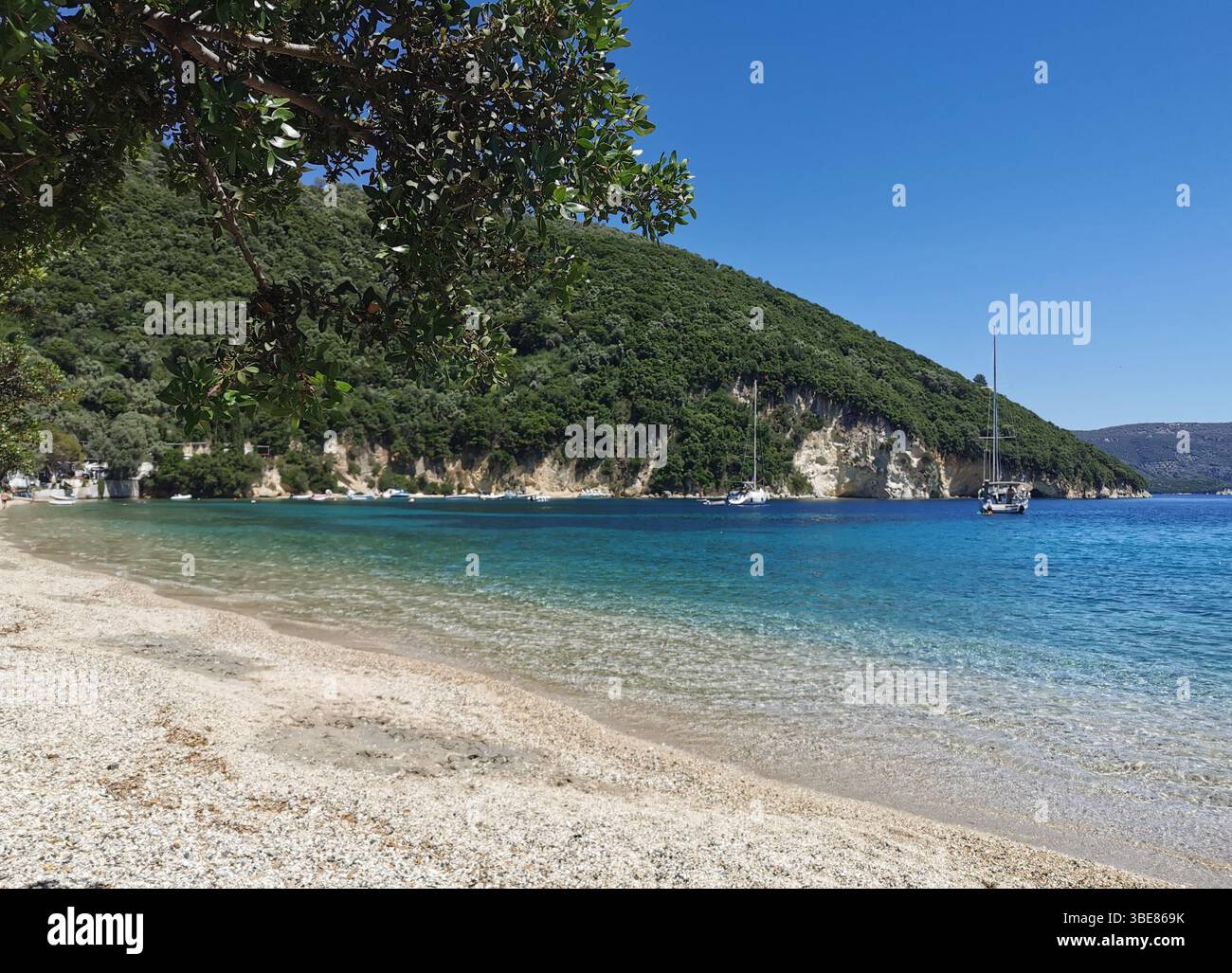 Desimi Kieselstrand in der Nähe von Nidri auf der Insel Lefkada in Griechenland. Eine geschützte Bucht, die sich hervorragend zum Bootfahren, Paddeln, Schnorcheln und Schwimmen eignet. - Smartphone-aufgenommenes Stockfoto