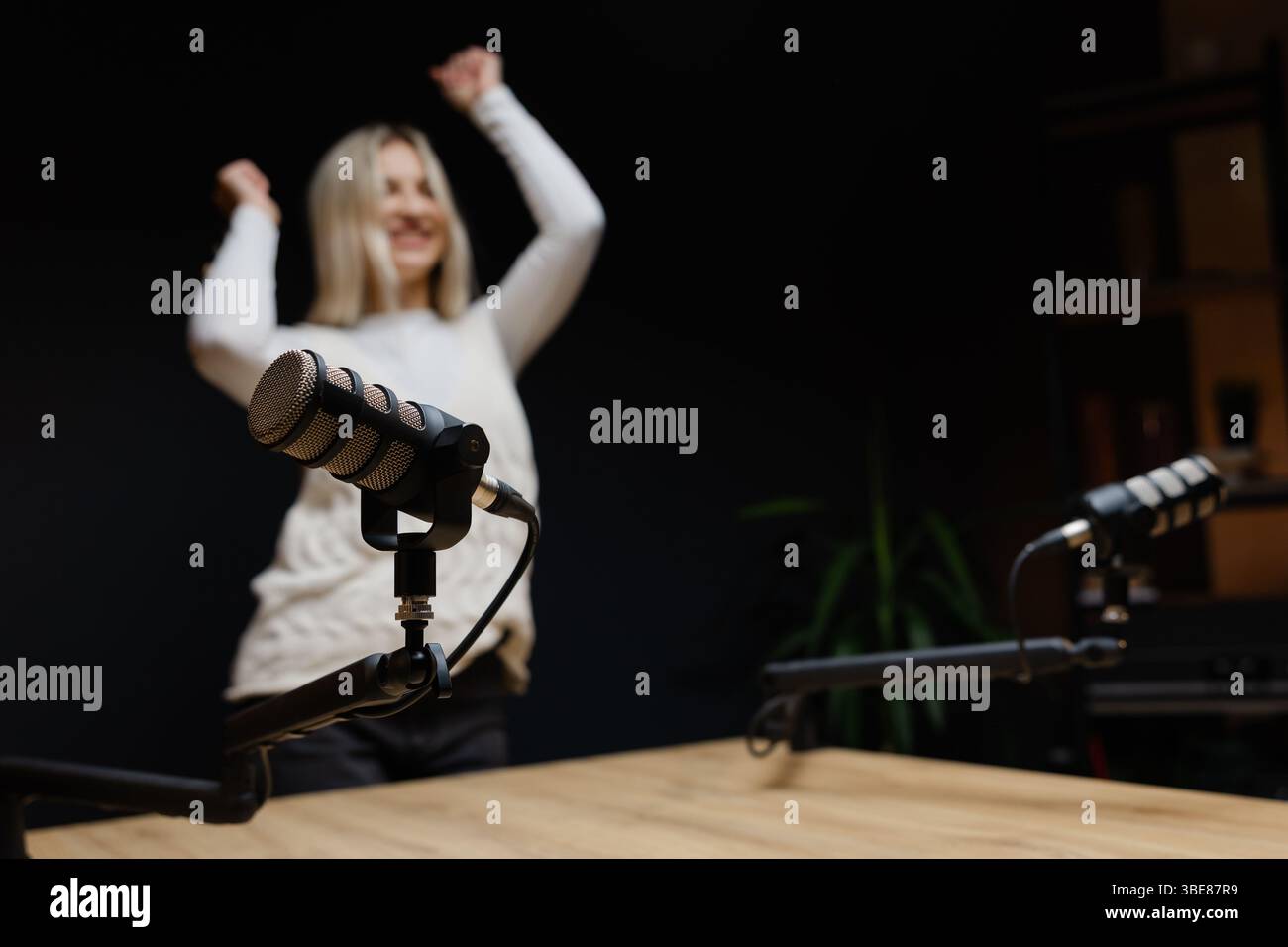 Weibliche Podcaster tanzen und lachen während einer Aufnahmesitzung in einem professionellen Studio und schaffen ansprechende Audioinhalte Stockfoto