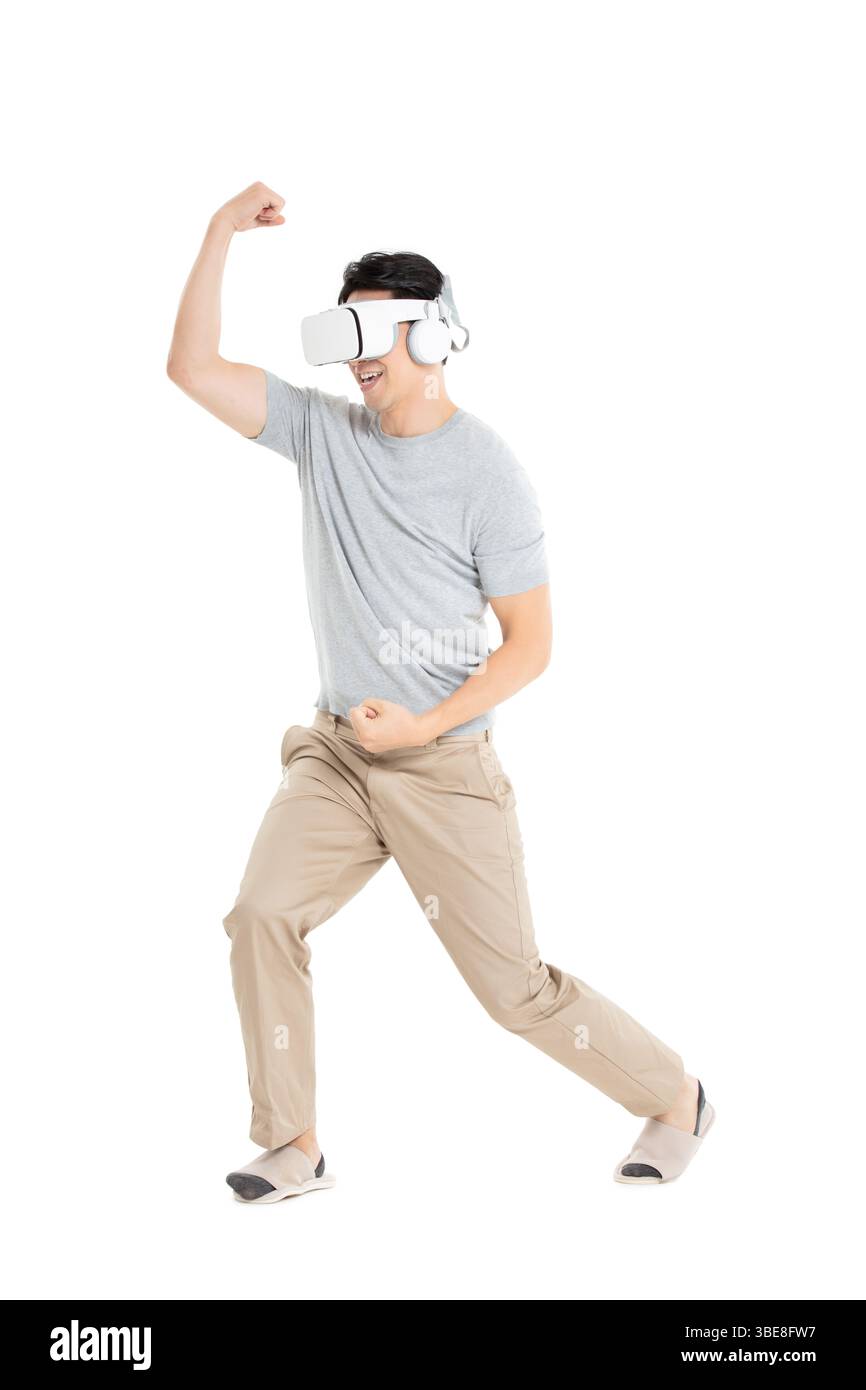 Ein junger Mann, der ein VR-Headset trägt und sich in immersiver Mensch-Maschine-Interaktion einsetzt Stockfoto