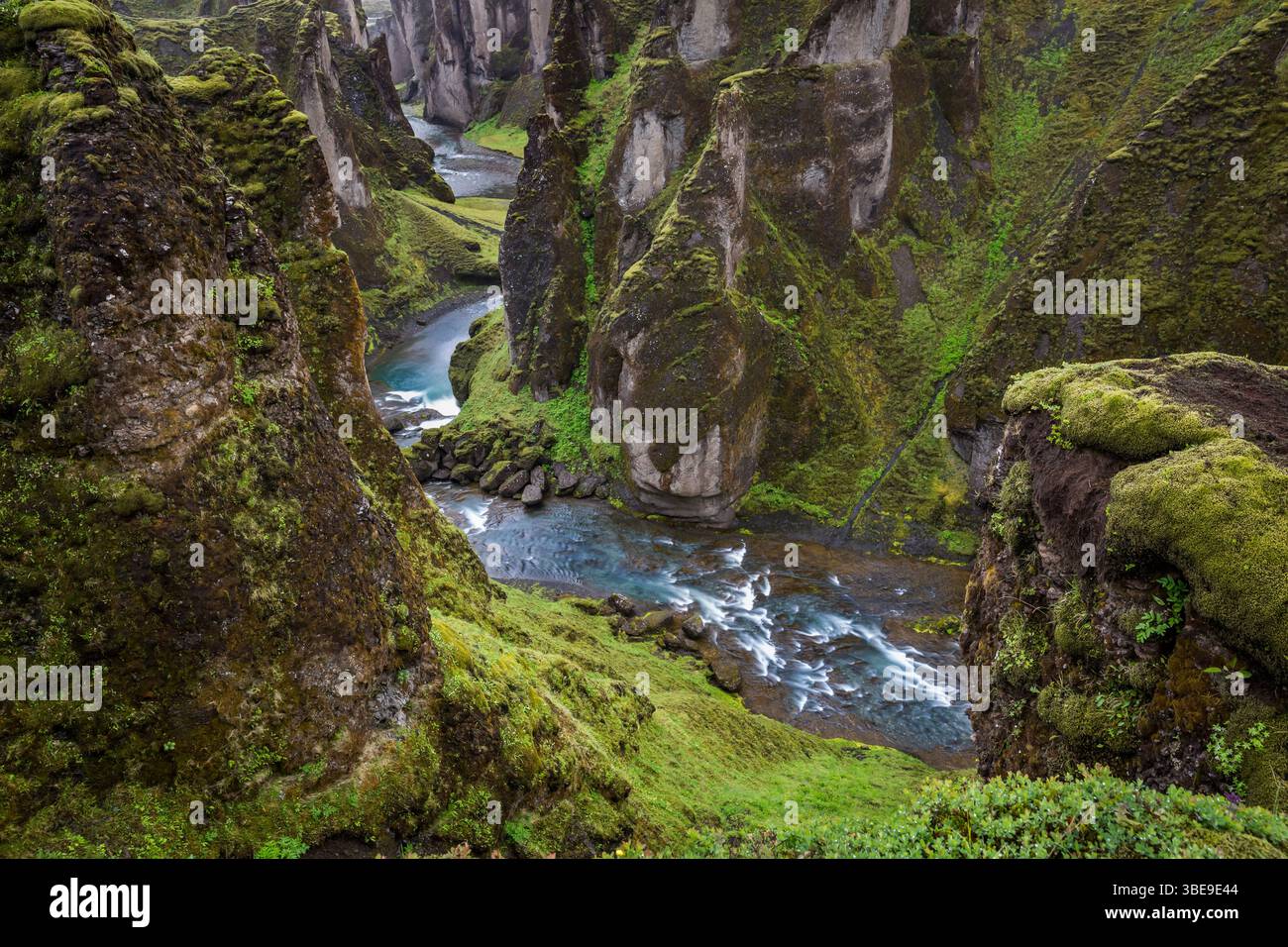 Blick auf den Fluss, der durch das Kanu Fjadrargljufur fließt, bedeckt mit grünem Gras und Moos auf Island dramatische Landschaft Stockfoto