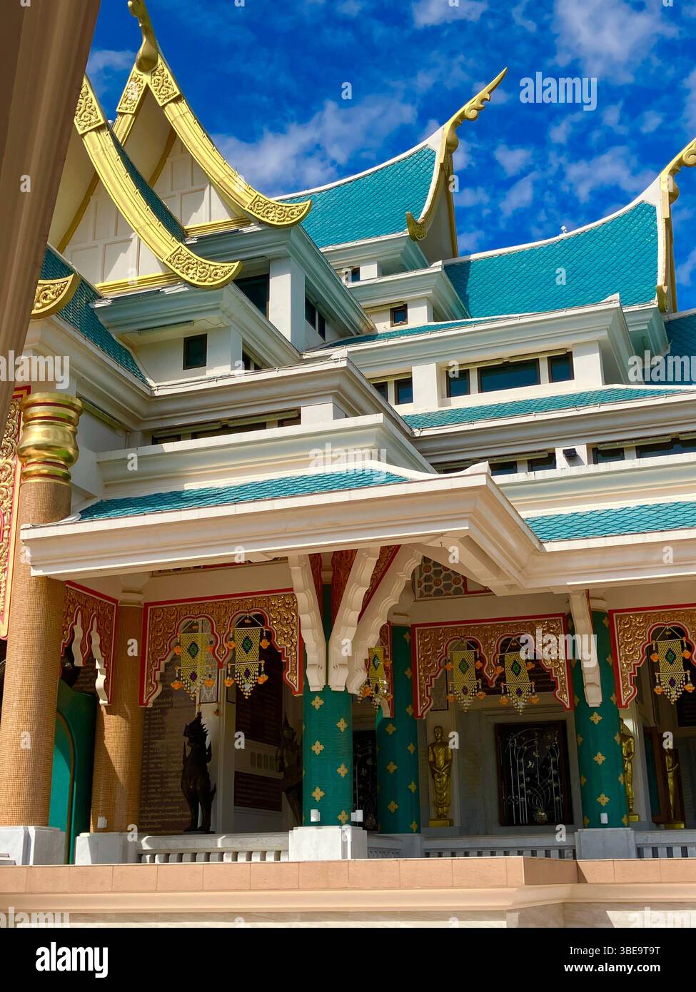 Traditioneller thailändischer buddhistischer Tempel unter klarem blauem Himmel. - Smartphone-aufgenommenes Stockfoto