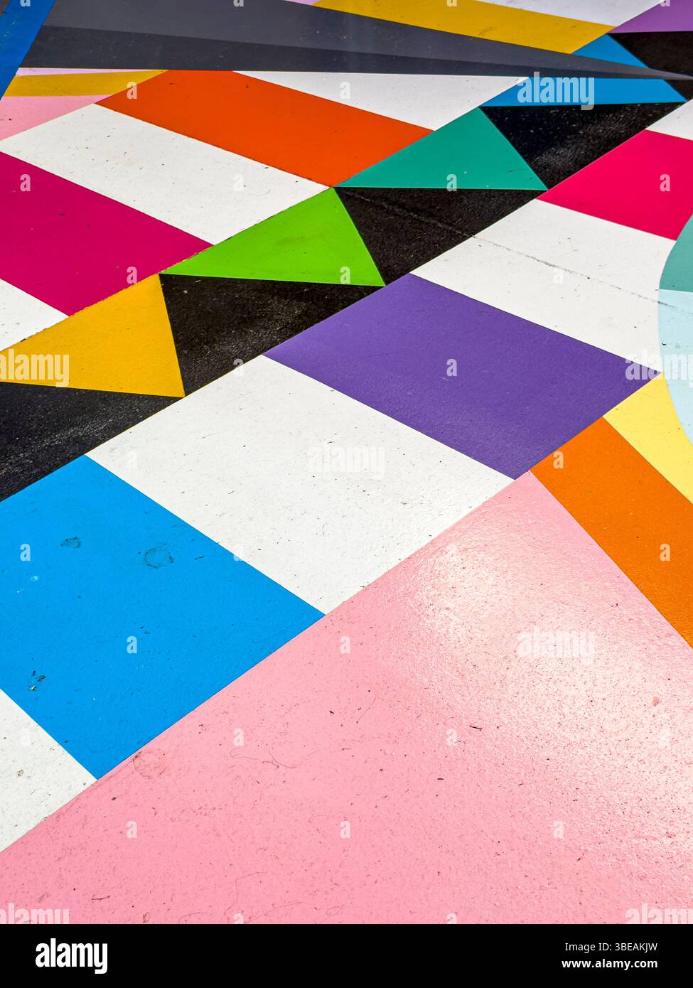 Lebendige Straßenkunst von Okuda San Miguel in Ibiza, Spanien – farbenfrohe geometrische Wandmalerei gegen blauen Himmel - Smartphone-aufgenommenes Stockfoto