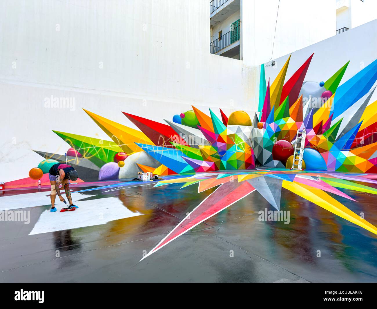 Lebendige Straßenkunst von Okuda San Miguel in Ibiza, Spanien – farbenfrohe geometrische Wandmalerei gegen blauen Himmel - Smartphone-aufgenommenes Stockfoto