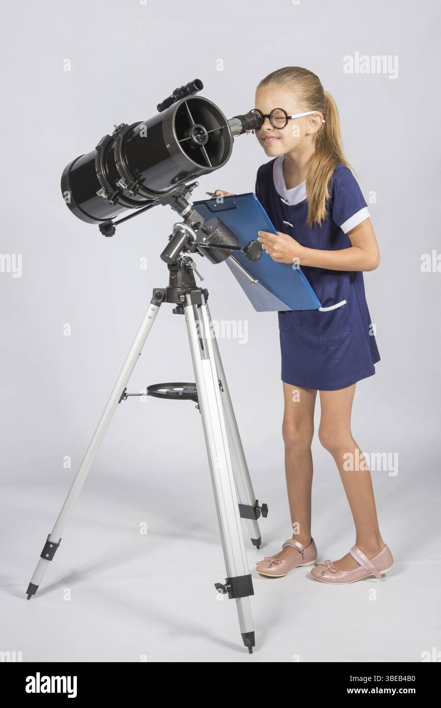 Der junge Astronom in Gläsern mit Interesse schaut in das Okular des Teleskops Stockfoto