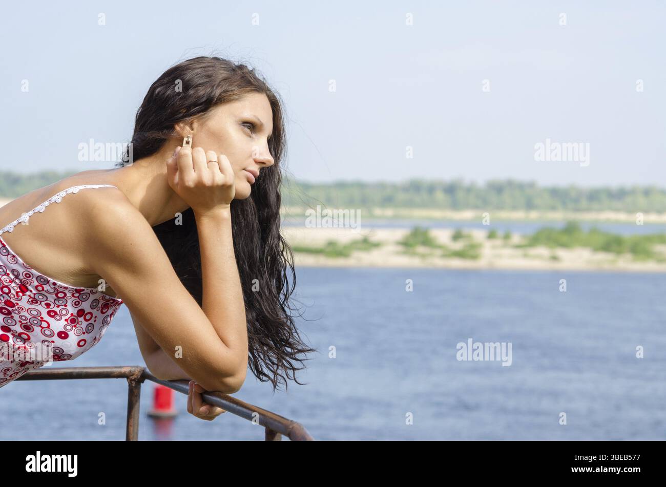 Junge Brünette Mädchen suchen nachdenklich in die Ferne auf dem Hintergrund des Flusses Stockfoto