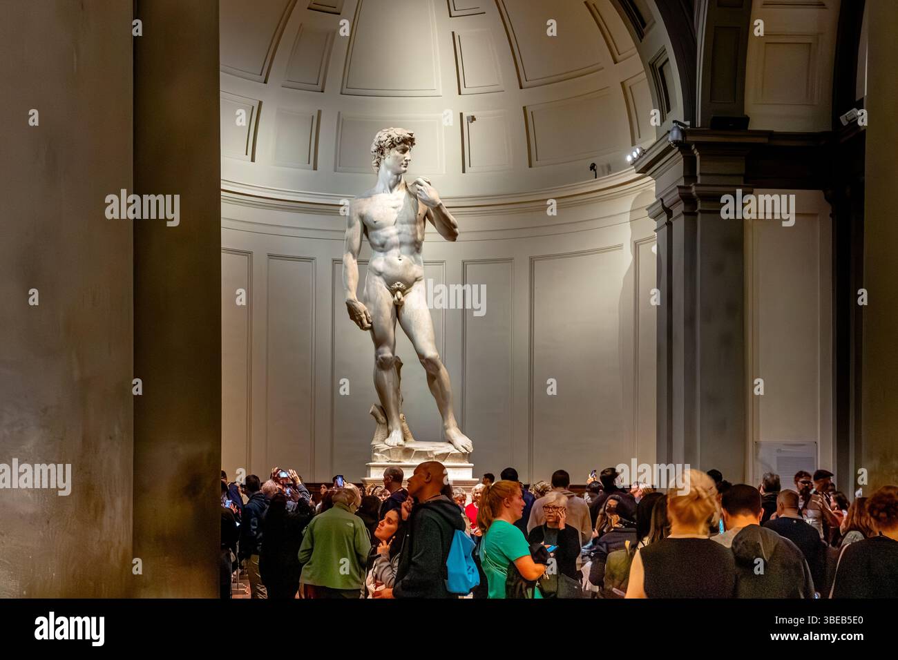 Menschenmassen schauen Michelangelos David, eine Skulptur aus Marmor, die in der Galleria dell’Accademia di Firenze, Florenz, Italien, ausgestellt ist Stockfoto